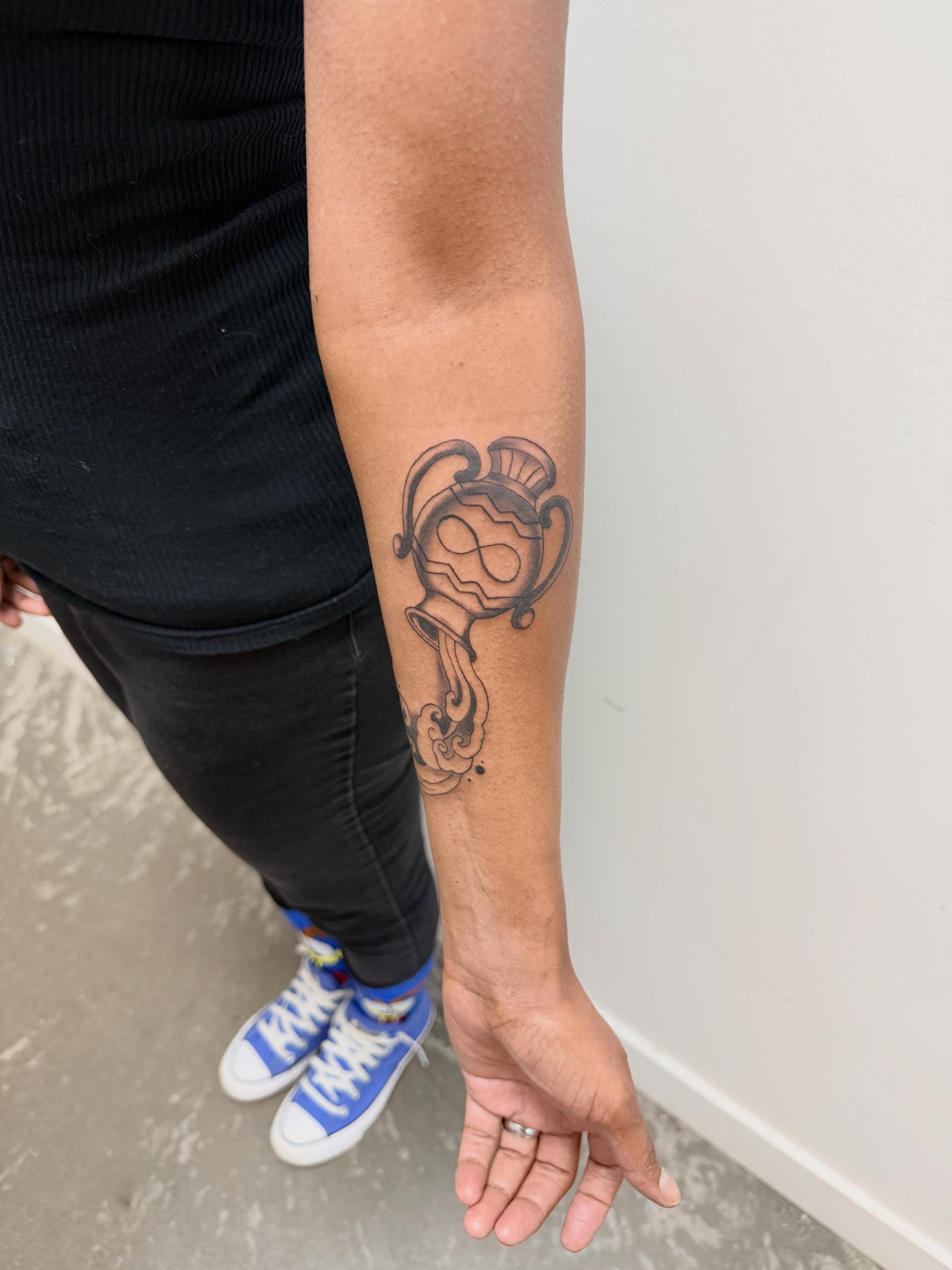 Hourglass black and grey tattoo on the forearm by Ellari