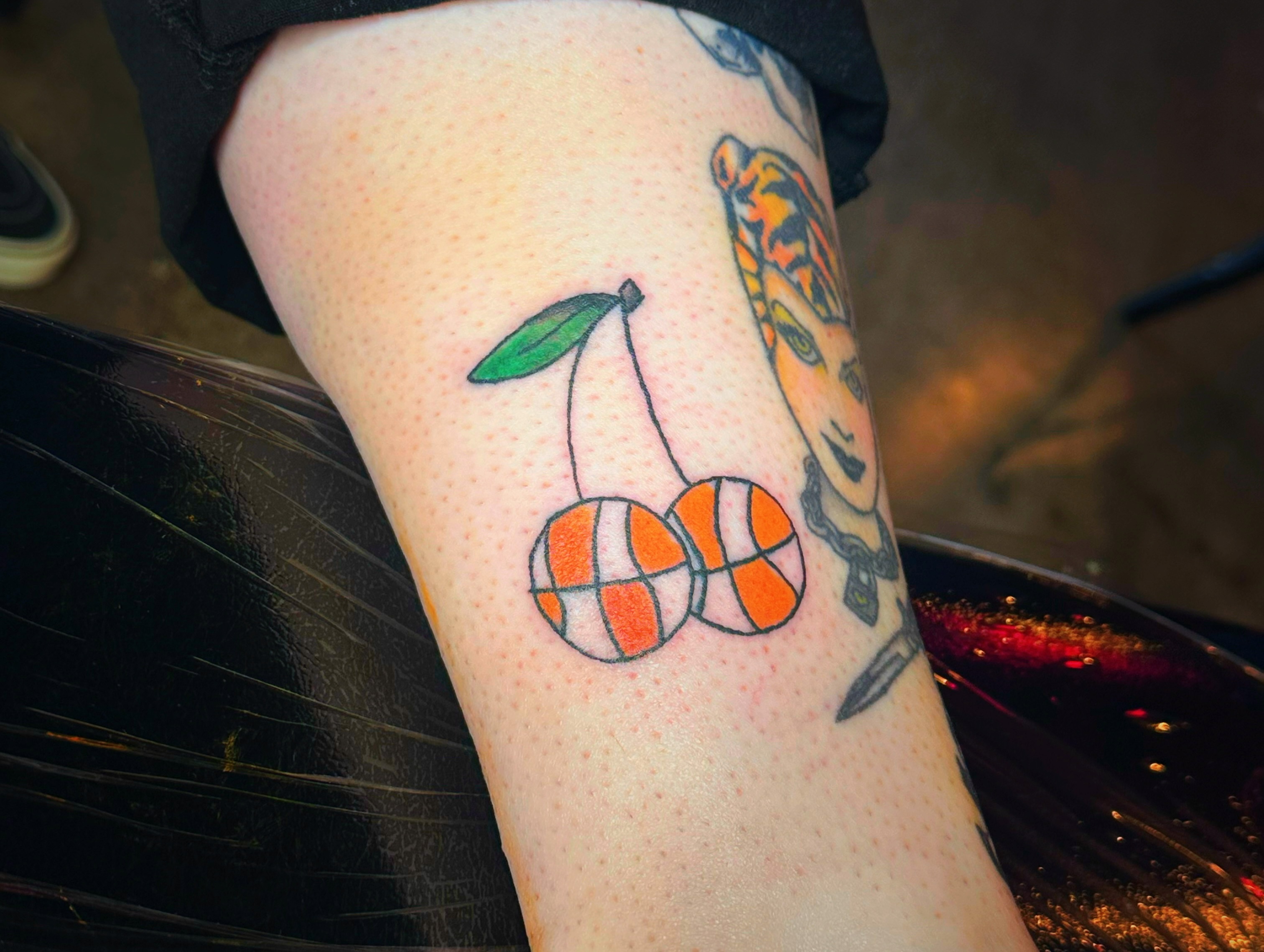 Cherry and basketballs dotwork tattoo on the thigh by Madeline Seeley