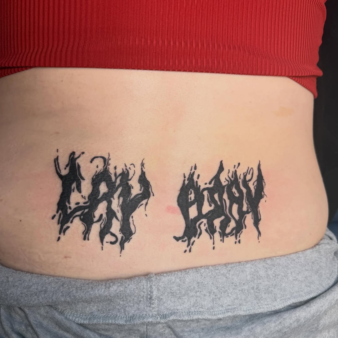 Lettering black and grey tattoo on the torso by Abby