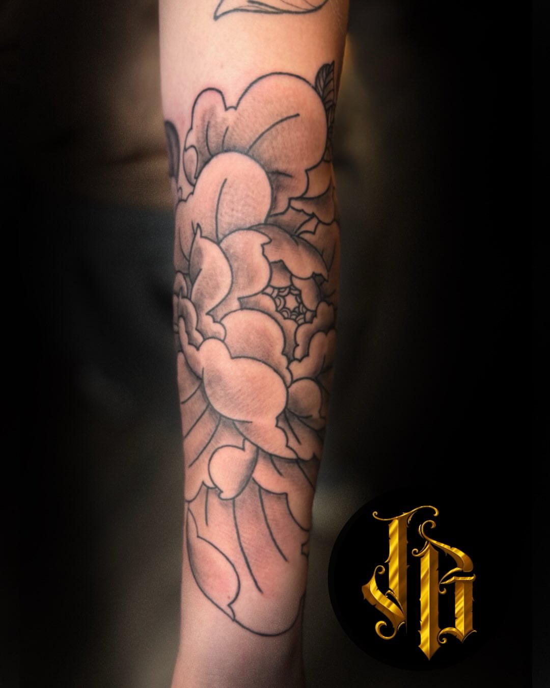 Peony black and grey tattoo on the forearm by James Brooks
