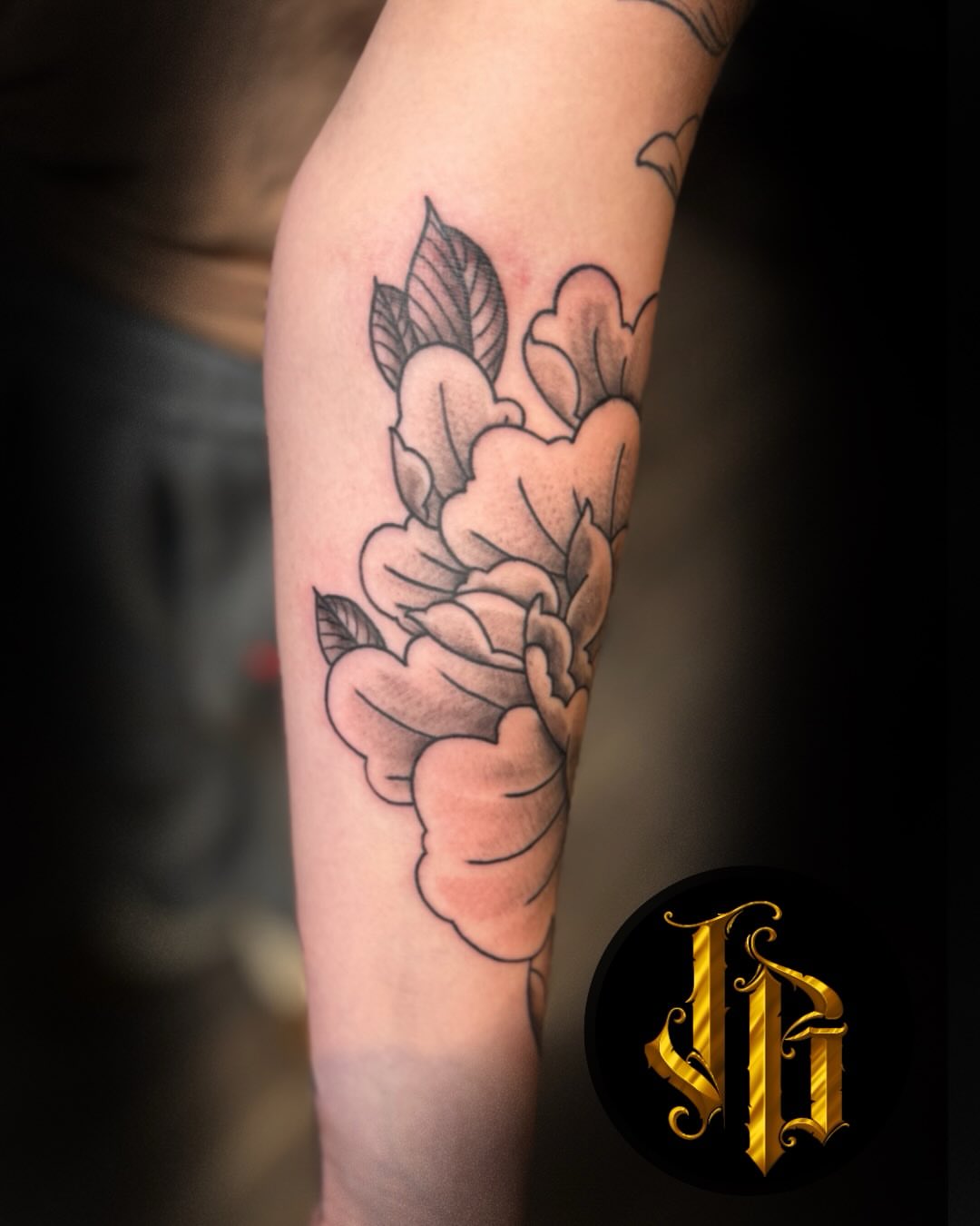 Peony black and grey tattoo on the forearm by James Brooks