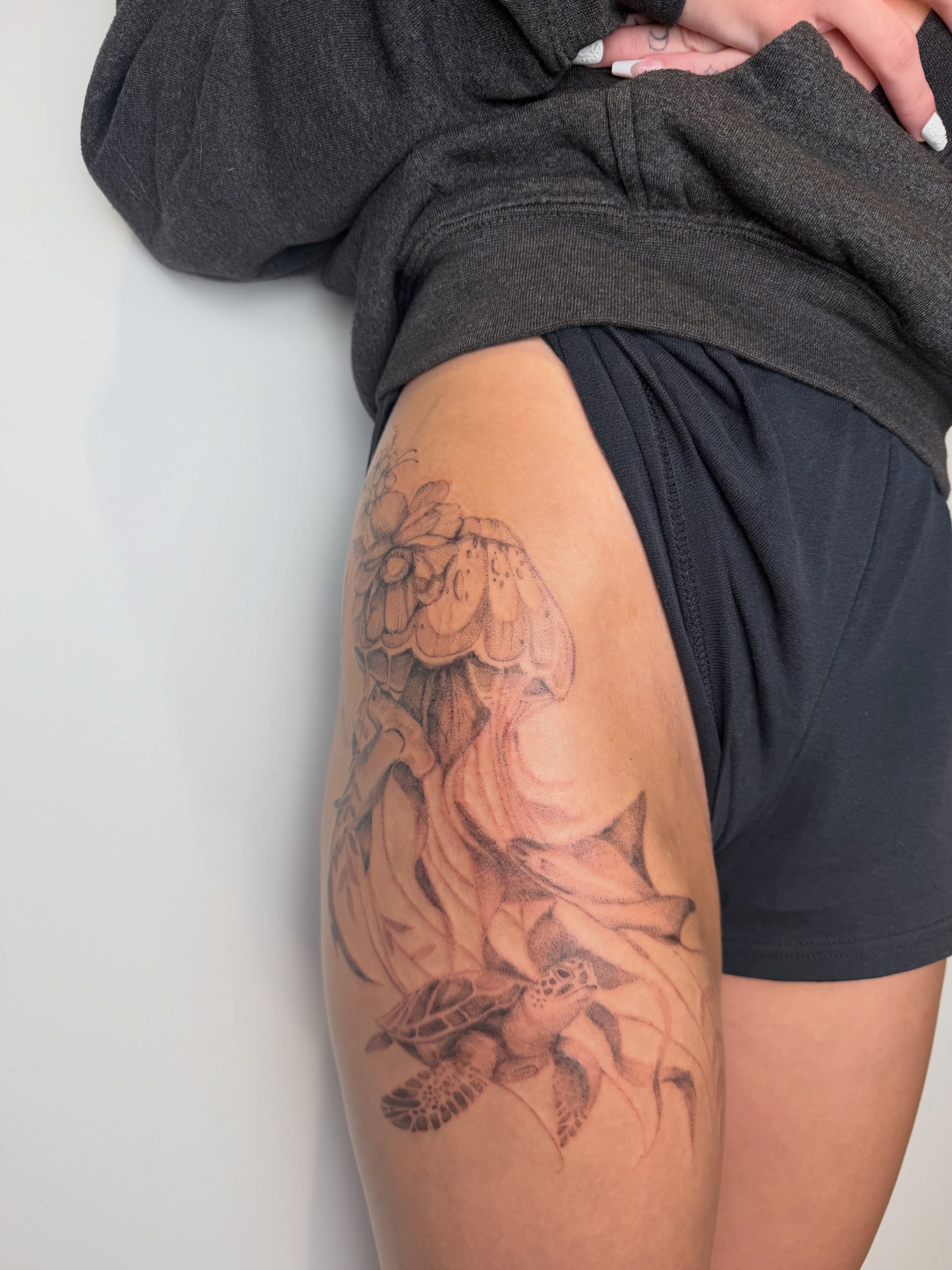 Sea turtle and flowers realism tattoo on the thigh by Mackenzie