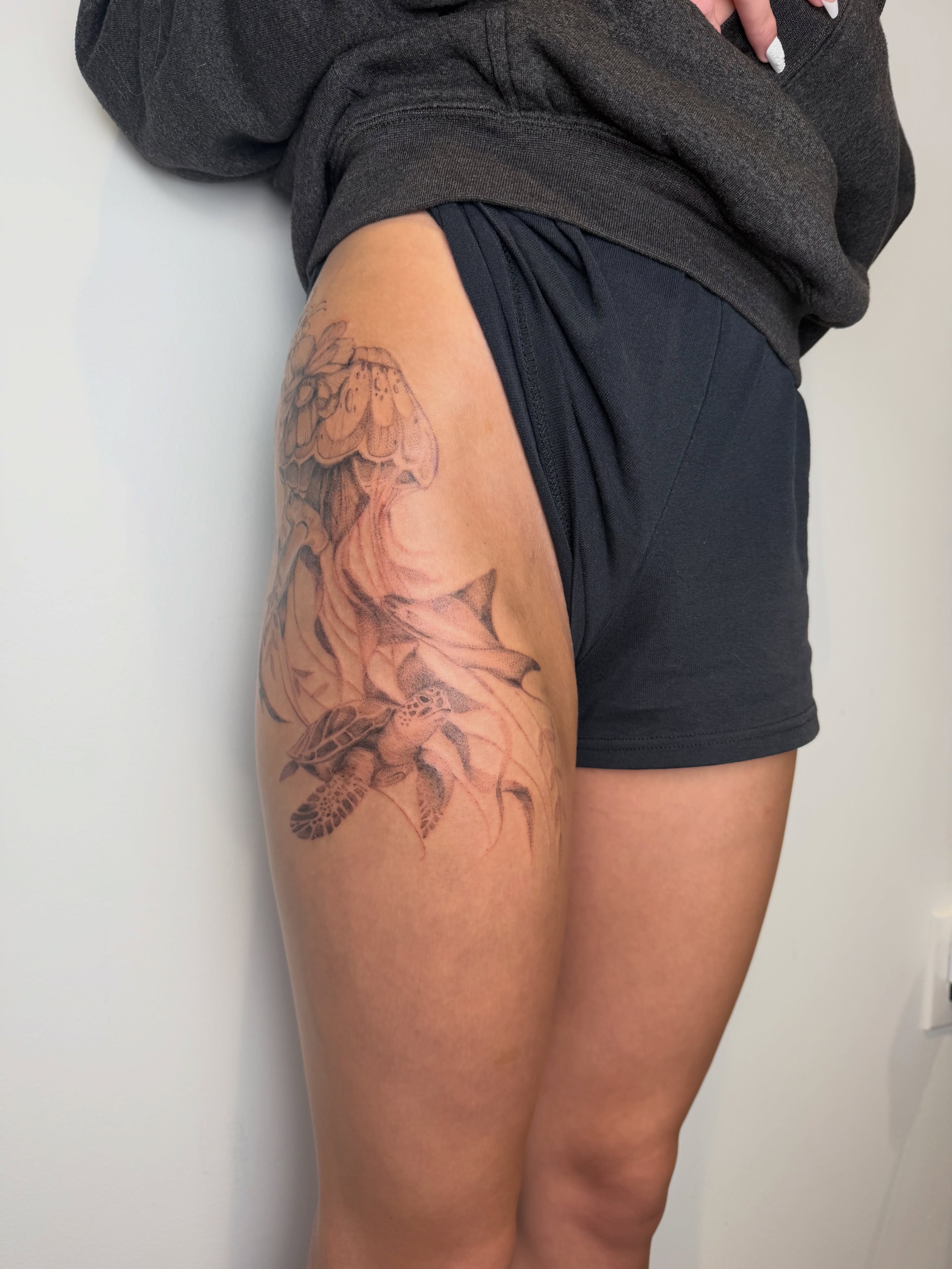 Floral arrangement realism tattoo on the thigh by Mackenzie
