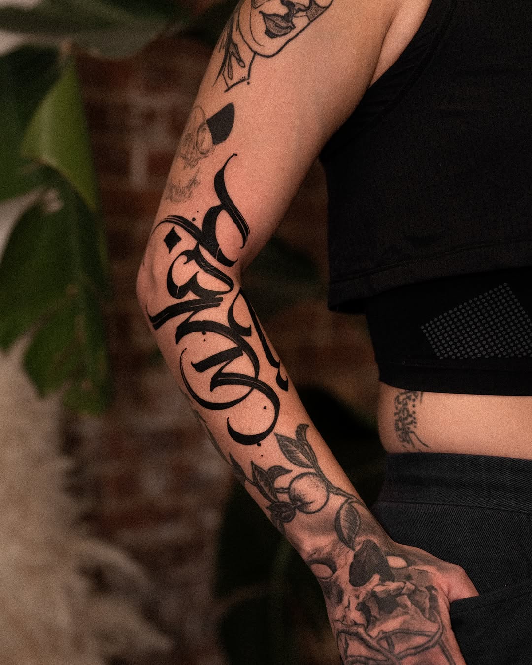 Calligraphy script blackwork tattoo on the forearm by Low, Brooklyn, New York