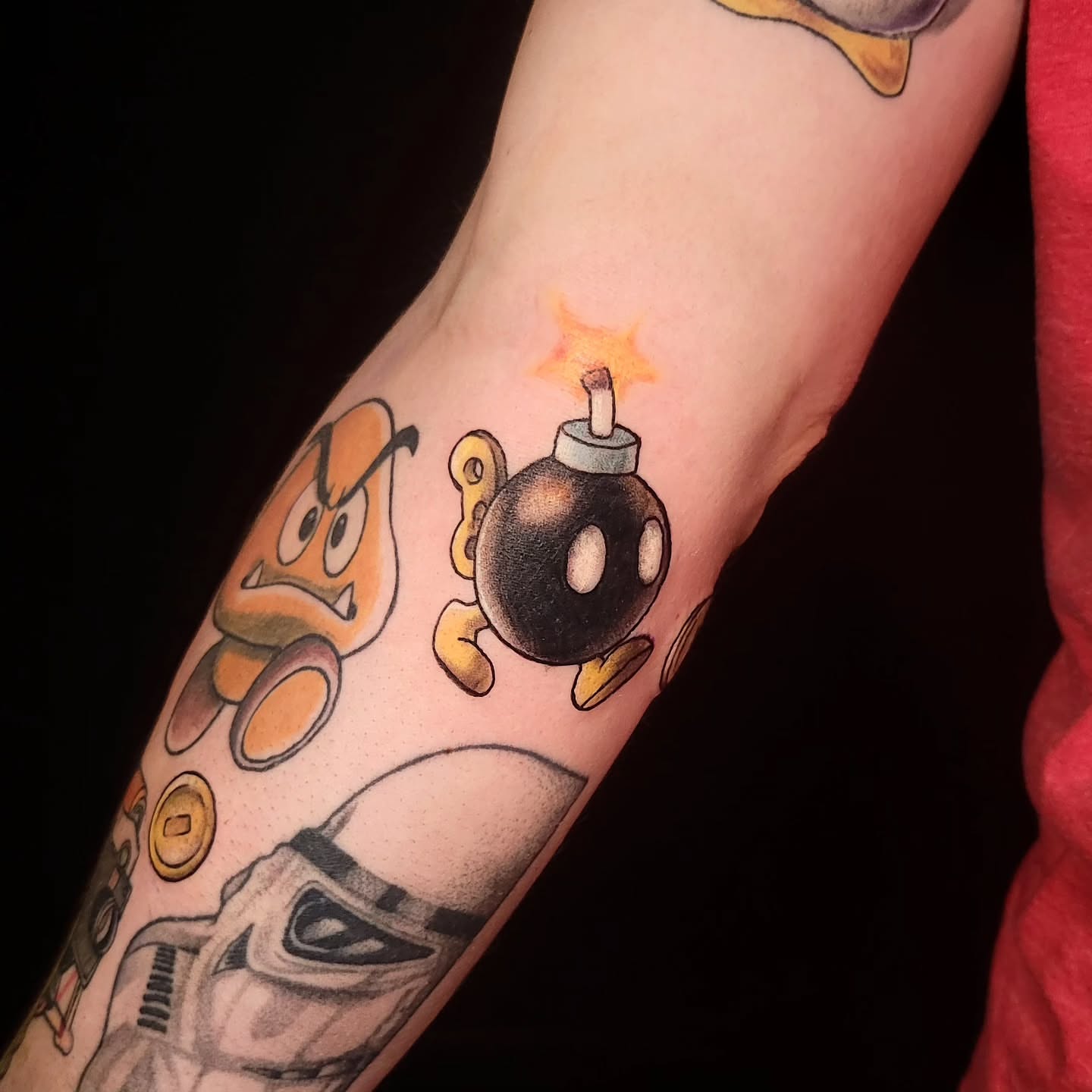 Mario bomb and goomba new school tattoo on the forearm by Sarah Alba