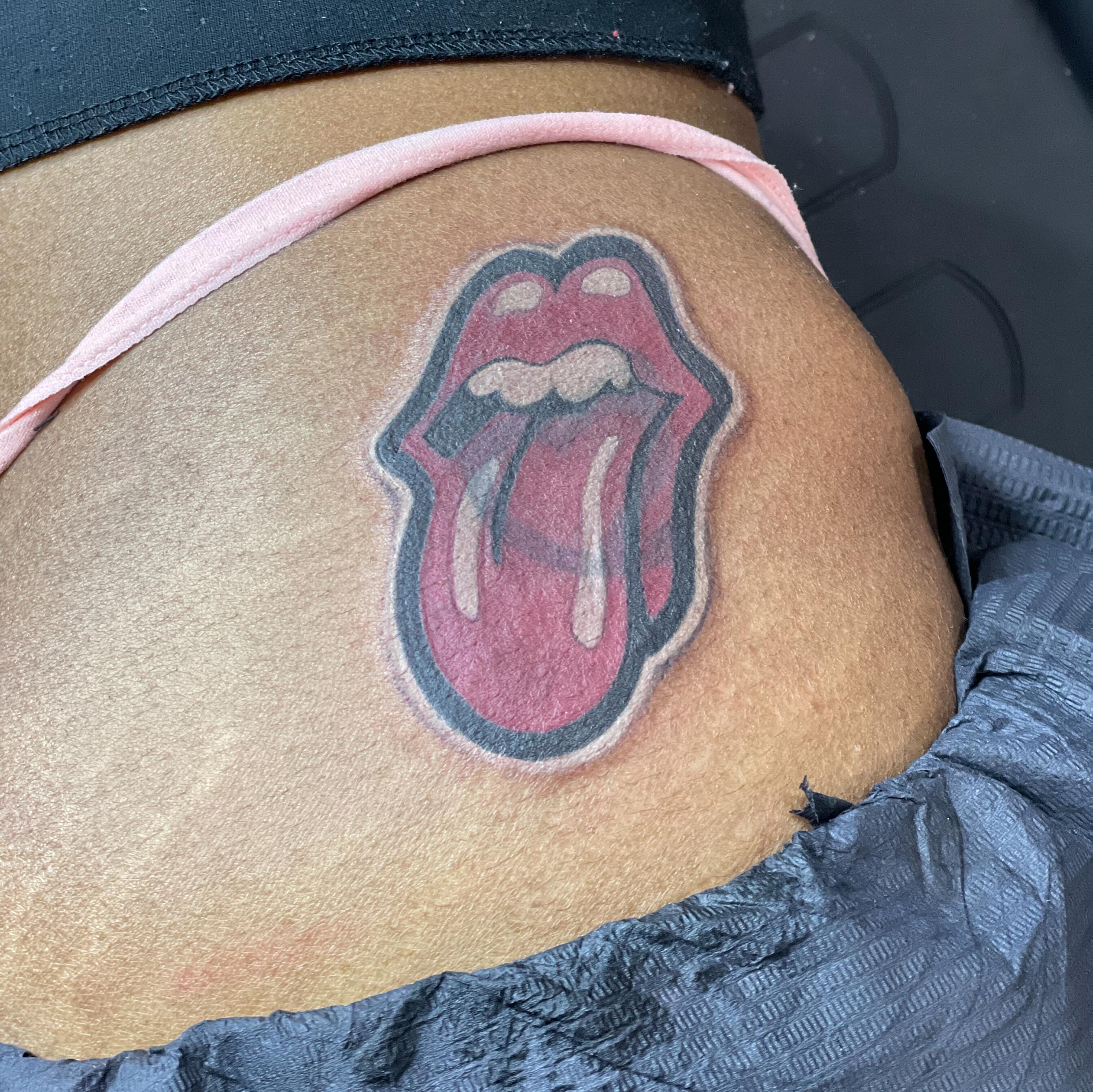 Rolling stones tongue black and grey tattoo on the thigh by D. Davis