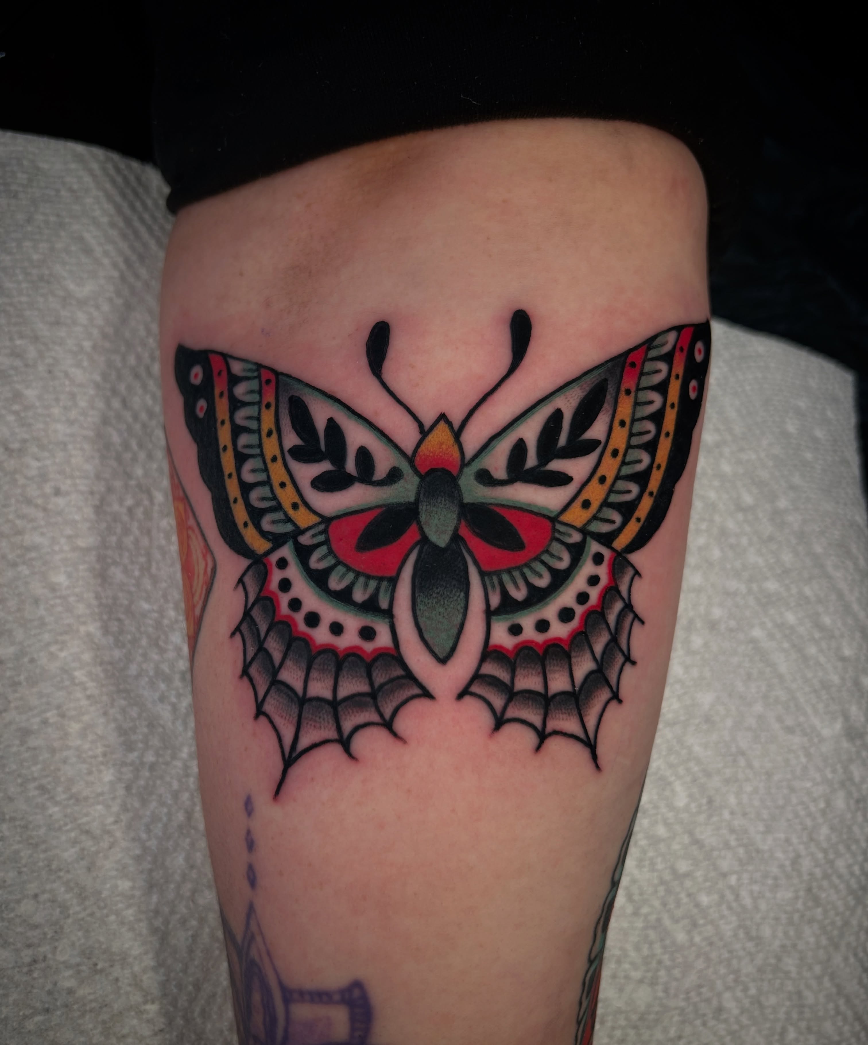 Butterfly American traditional tattoo on the thigh by Kit Miller, Indianapolis, Indiana