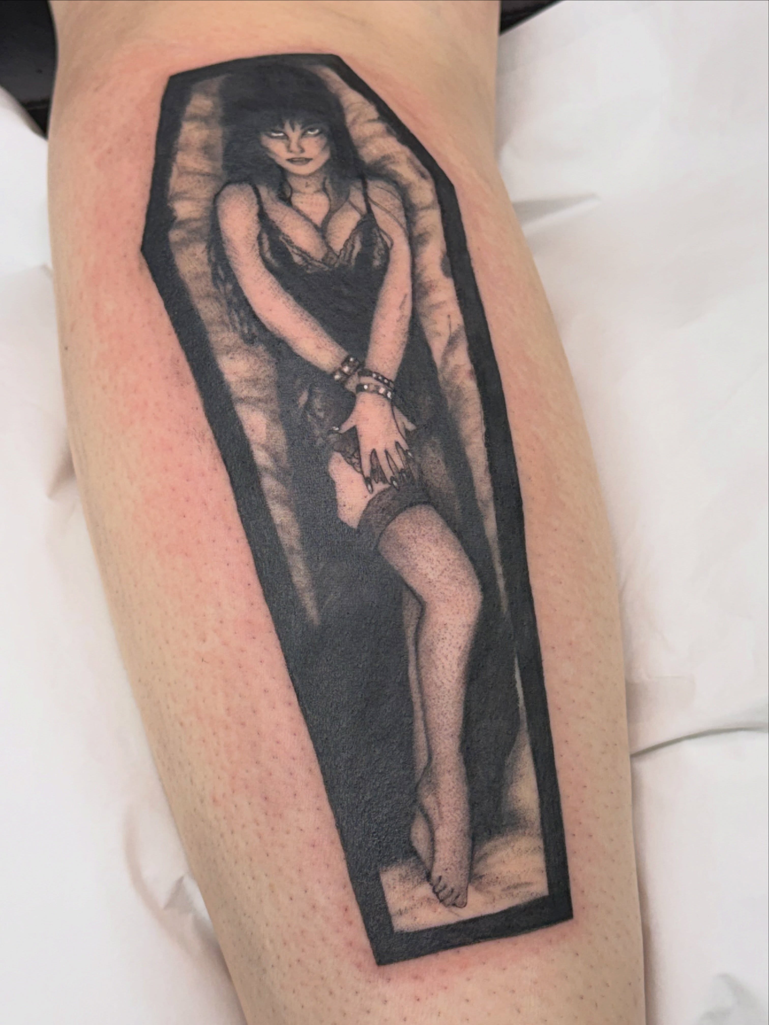 Woman in coffin realism tattoo on the leg by Halle Cooper