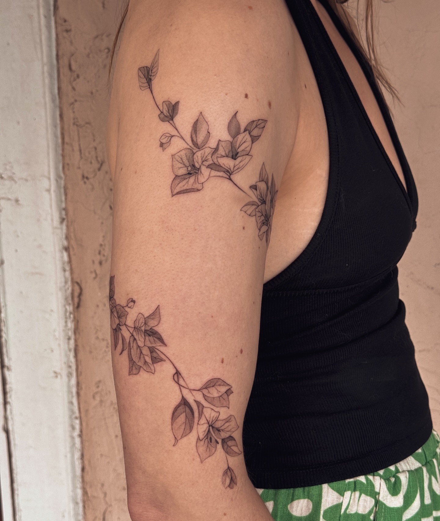 Flower vine black and grey tattoo on the upper arm by Floral