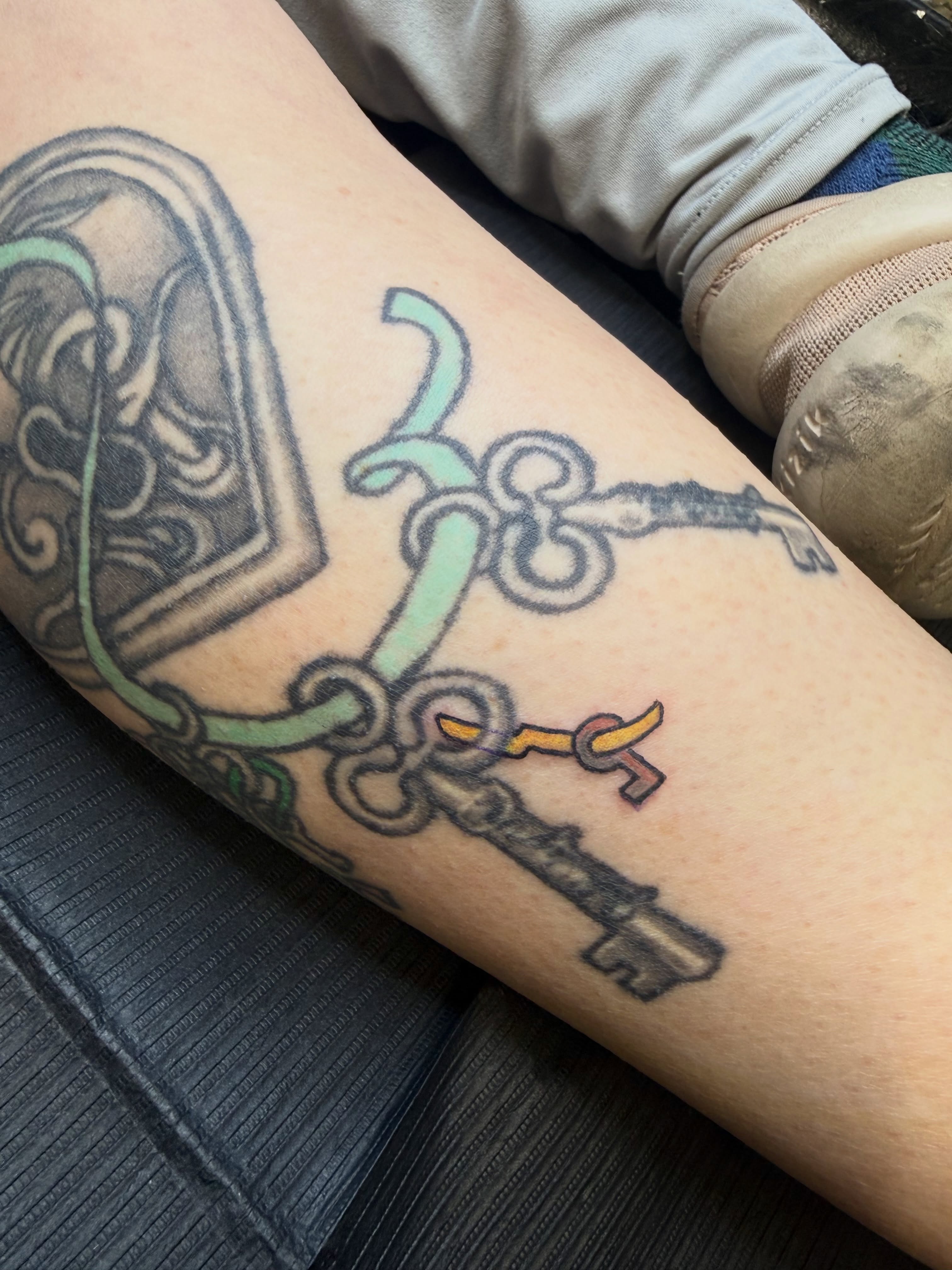Key and lock black and grey tattoo on the forearm by Jennifer Contreras
