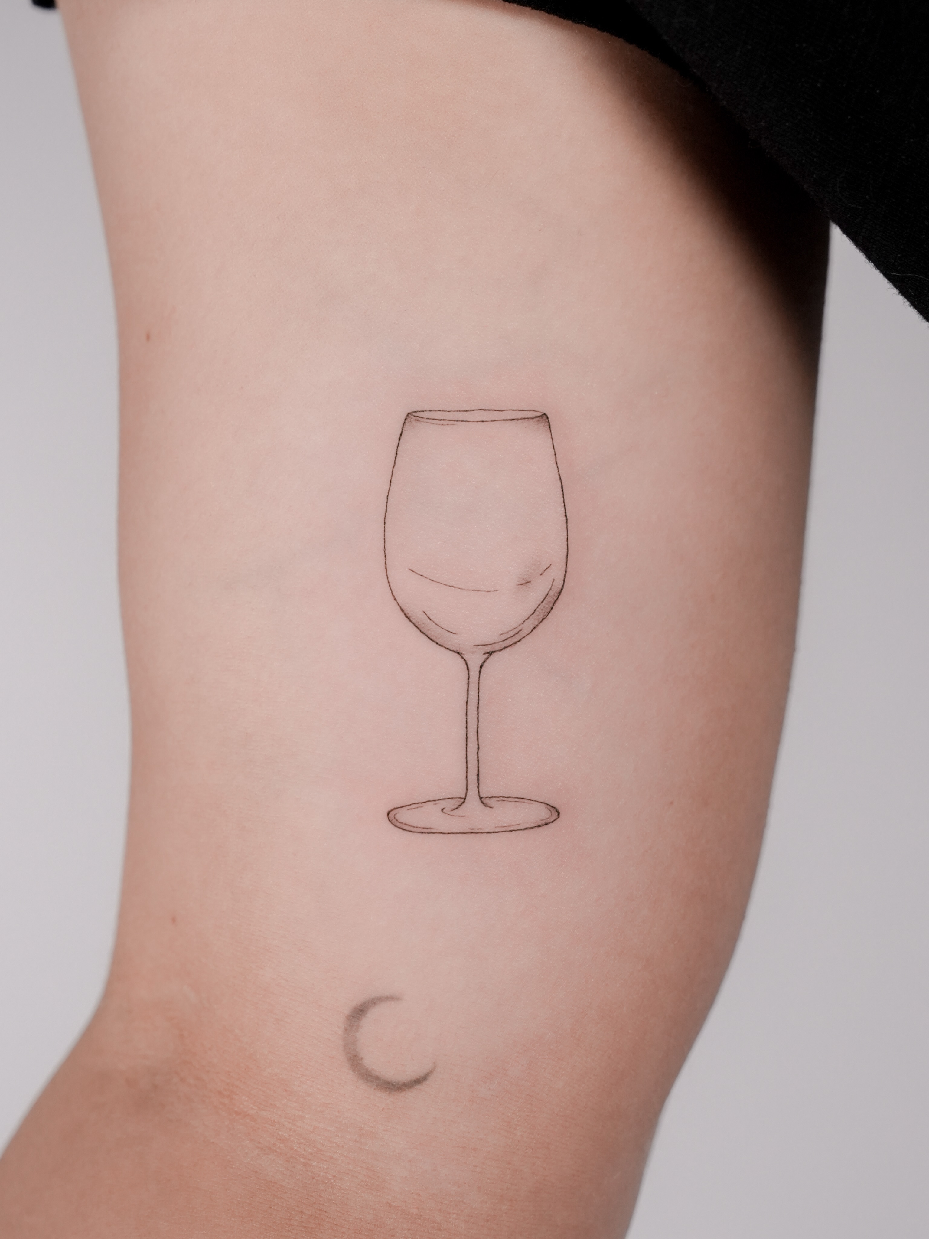Wine glass minimalist tattoo on the forearm by Ash - Fineline Tattoo Apprentice
