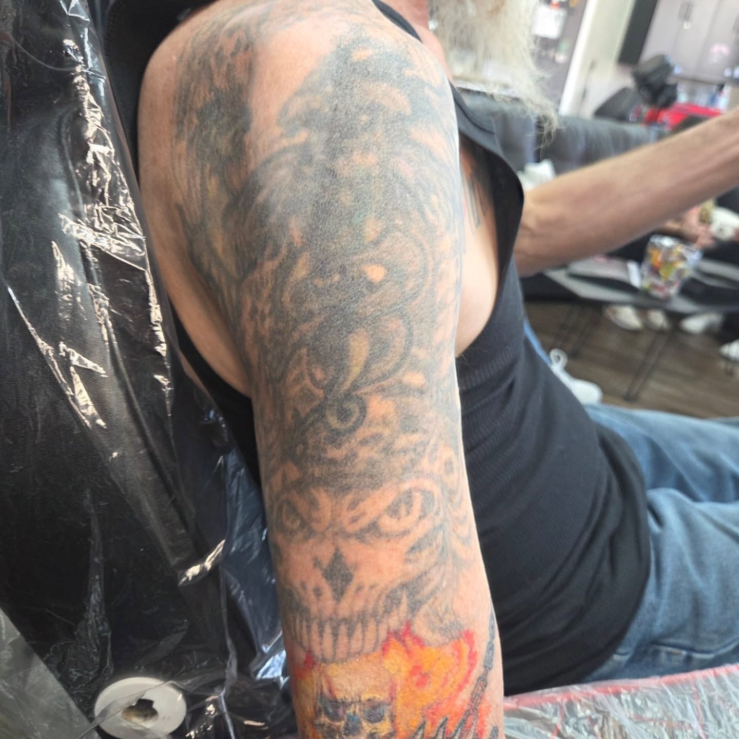 Skull black and grey tattoo on the upper arm by Matthew Todd Kremer