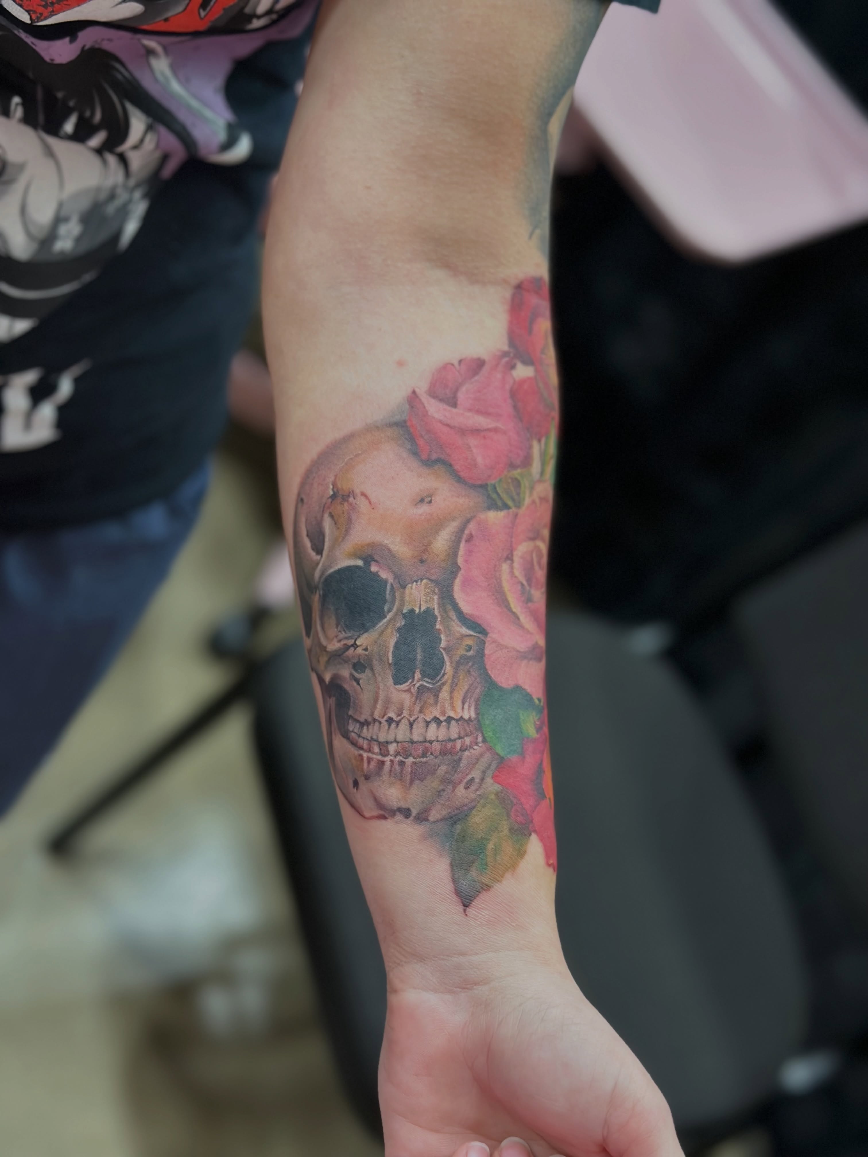 Skull and roses realism tattoo on the forearm by Elizabeth’s Eclectic Tattoos