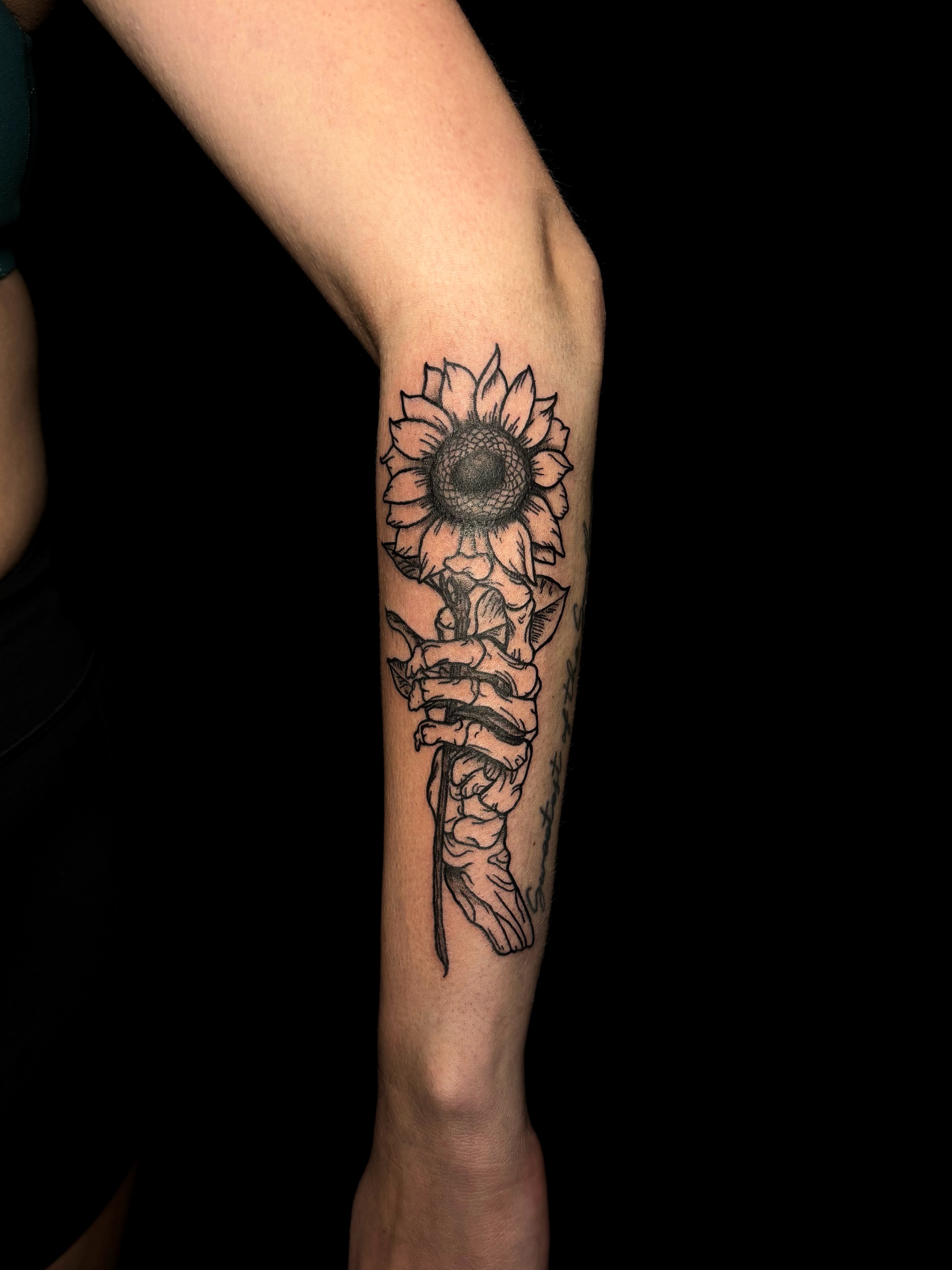 Sunflower and skeleton hand realism tattoo on the forearm by JT.tattoos