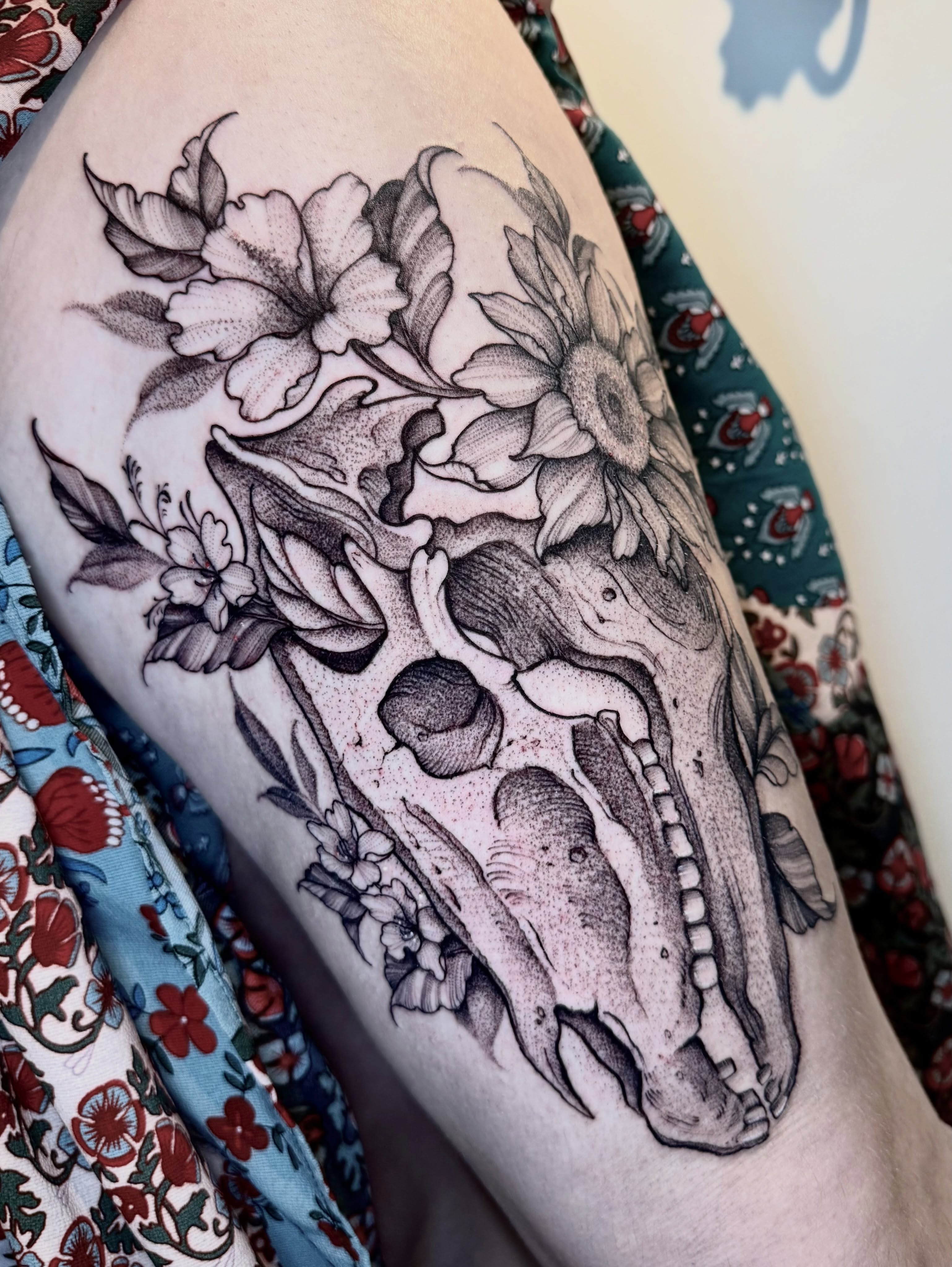 Skull and flowers dotwork tattoo on the thigh by ℳ𝒾𝓇𝓉𝒽𝒶 𝒯ℴ𝓇𝓇ℯ𝓈, San Diego, California