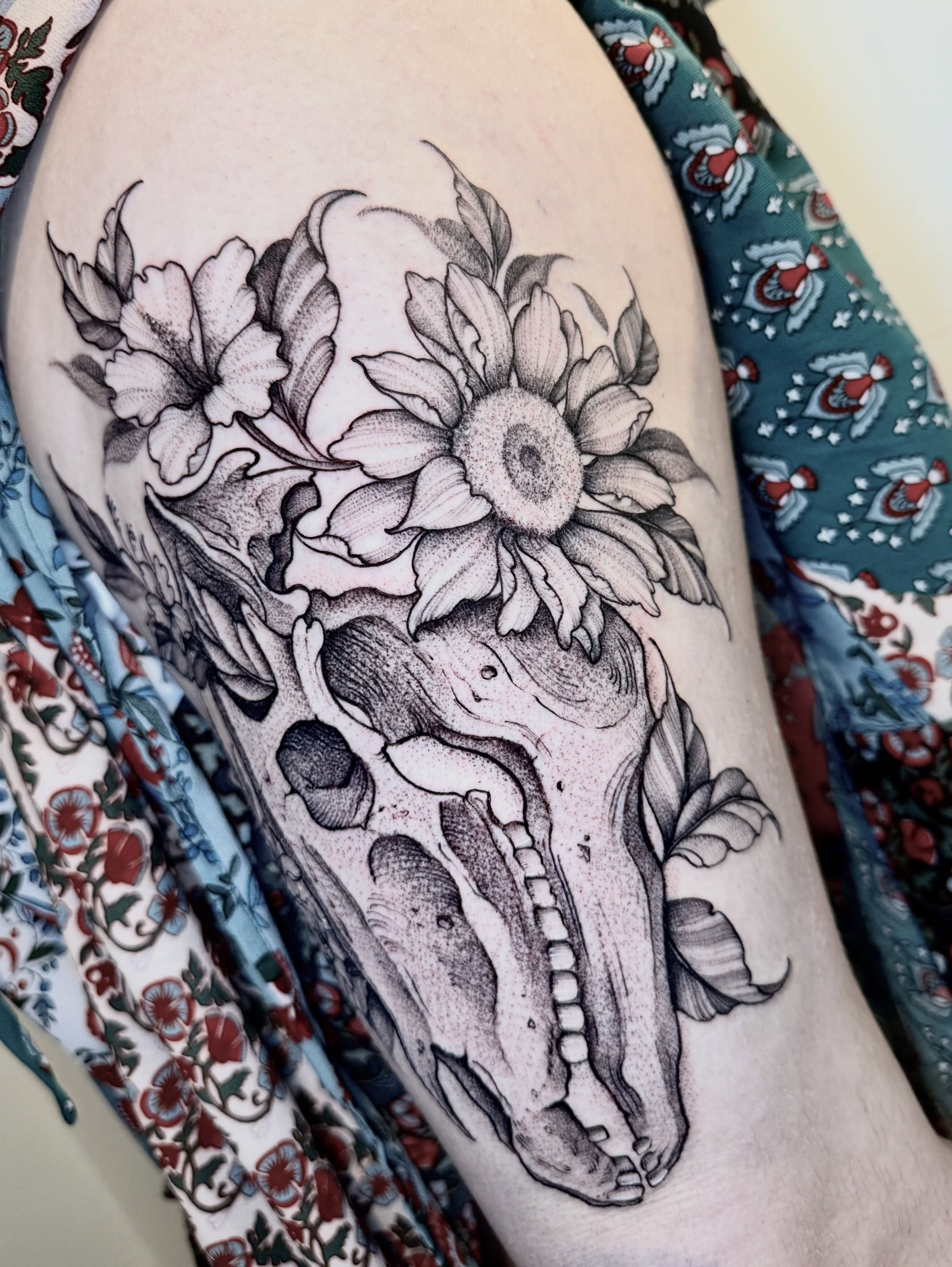 Skull and flowers dotwork tattoo on the thigh by ℳ𝒾𝓇𝓉𝒽𝒶 𝒯ℴ𝓇𝓇ℯ𝓈, San Diego, California
