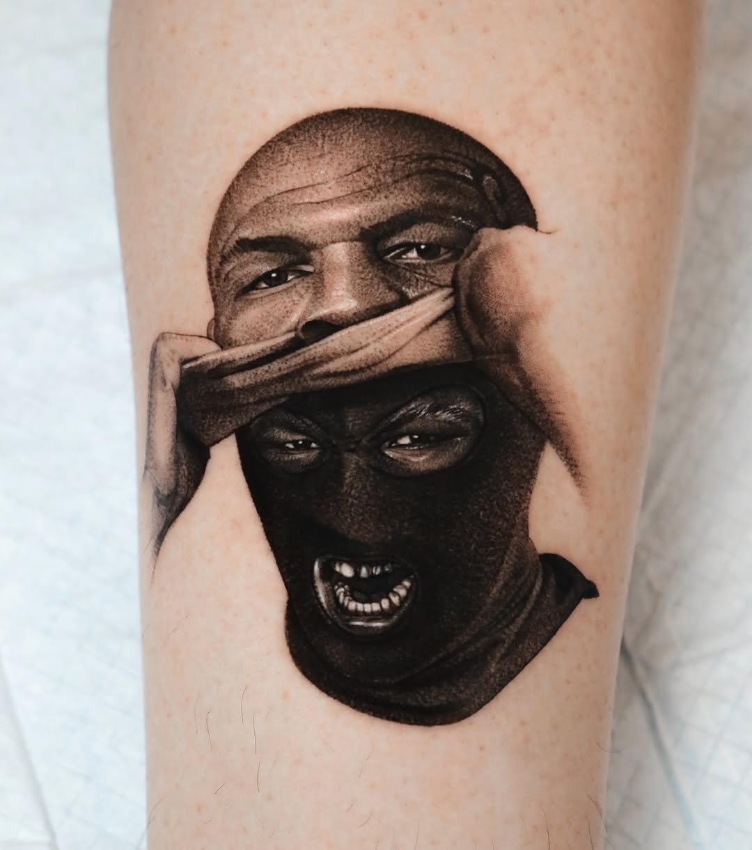 Man peeling off ski mask realism tattoo on the forearm by Saru