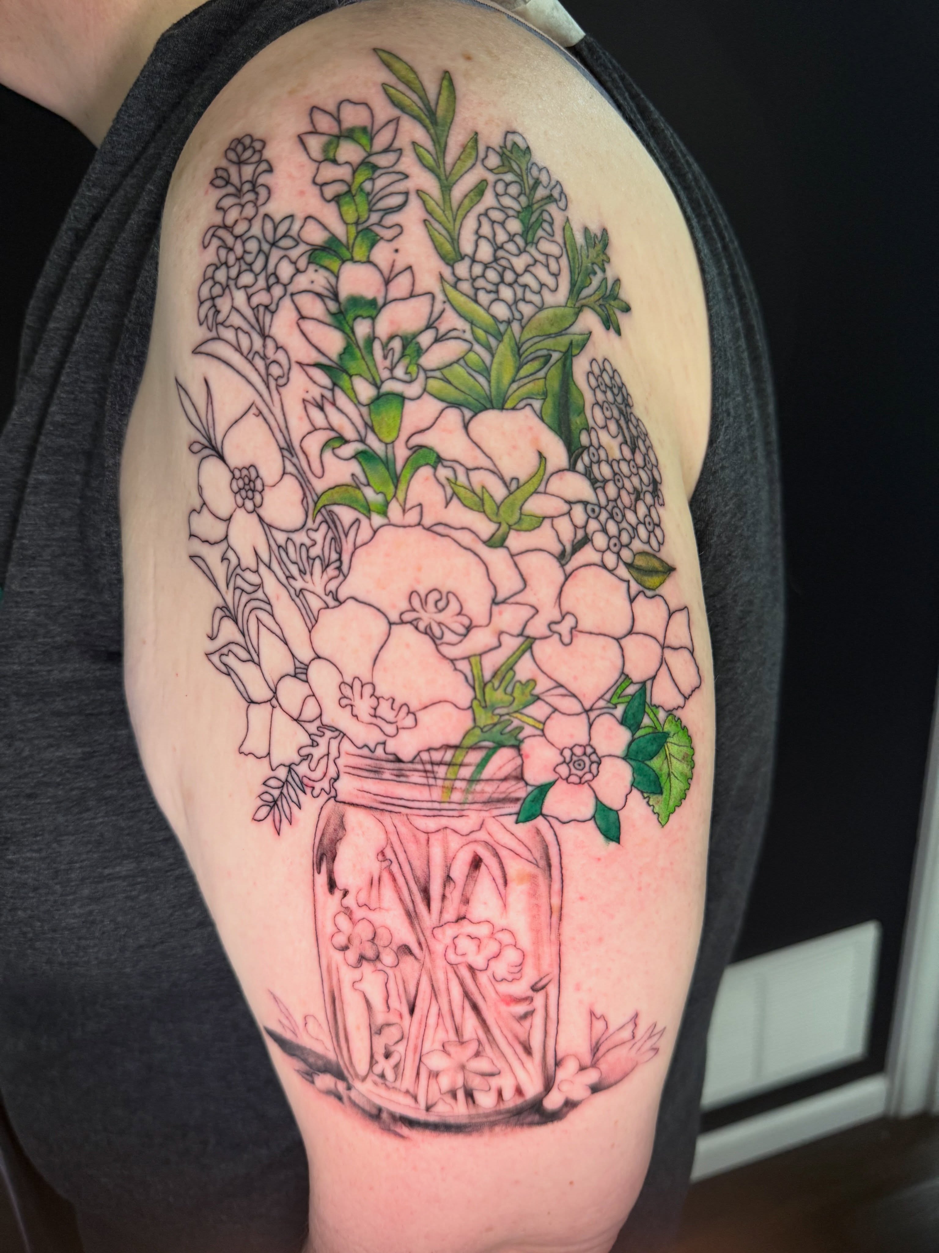 Flower bouquet black and grey tattoo on the upper arm by Michelle Balhan