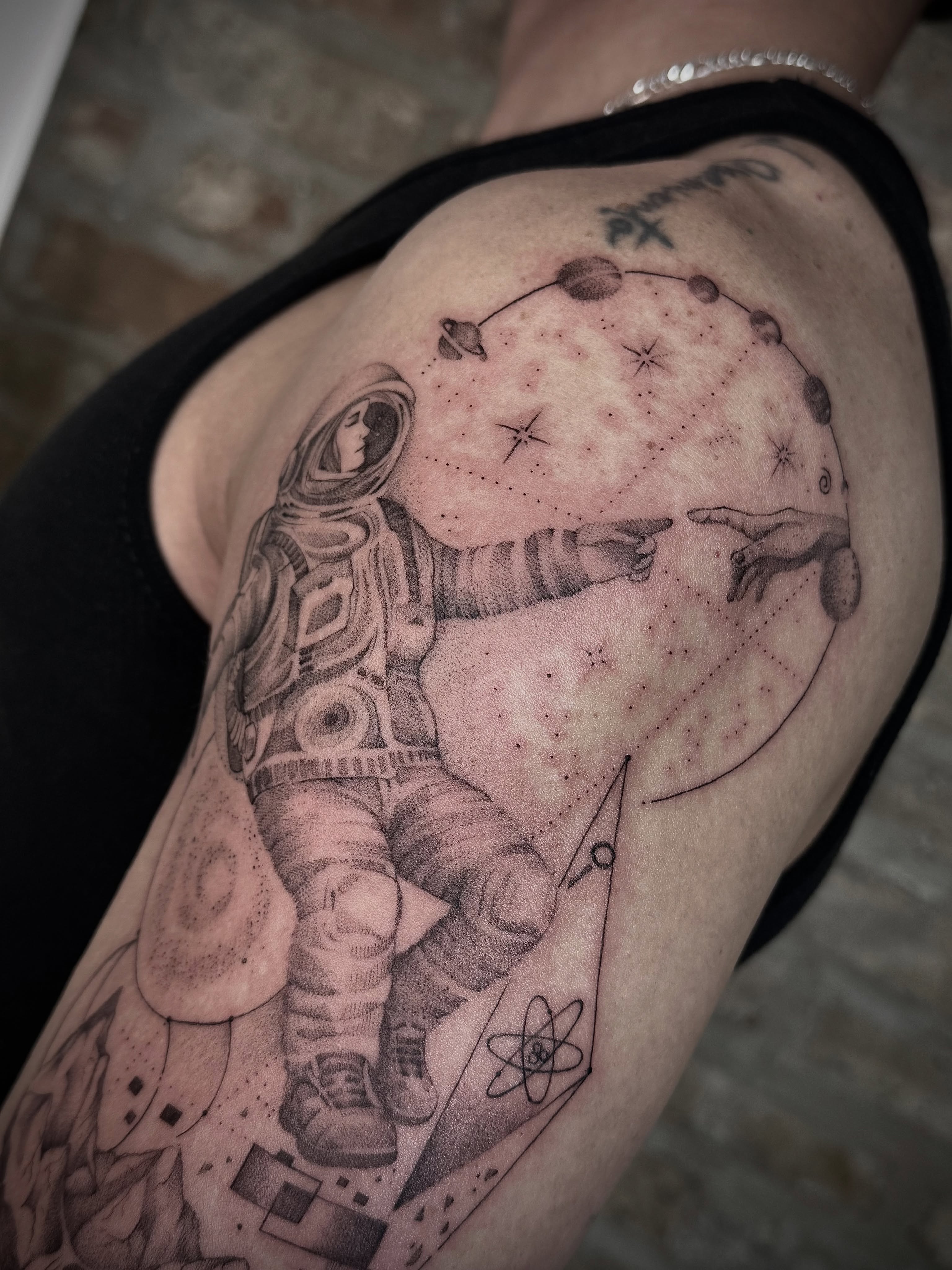 Astronaut and celestial map dotwork tattoo on the shoulder by Tattoo Yulia Kononenko
