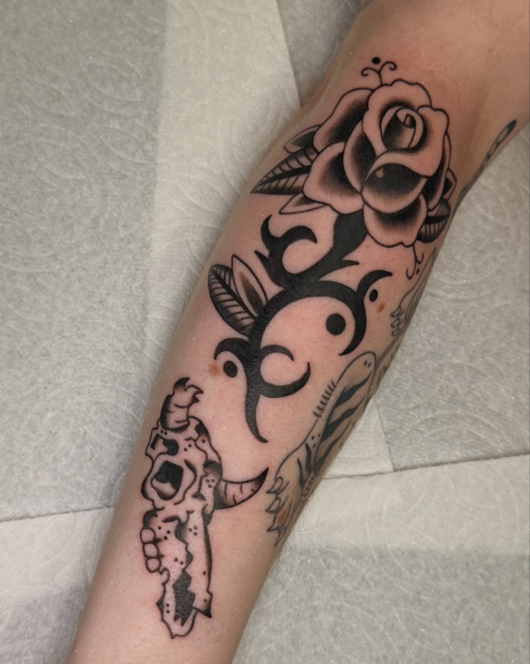 Rose and skull American traditional tattoo on the forearm by charlie