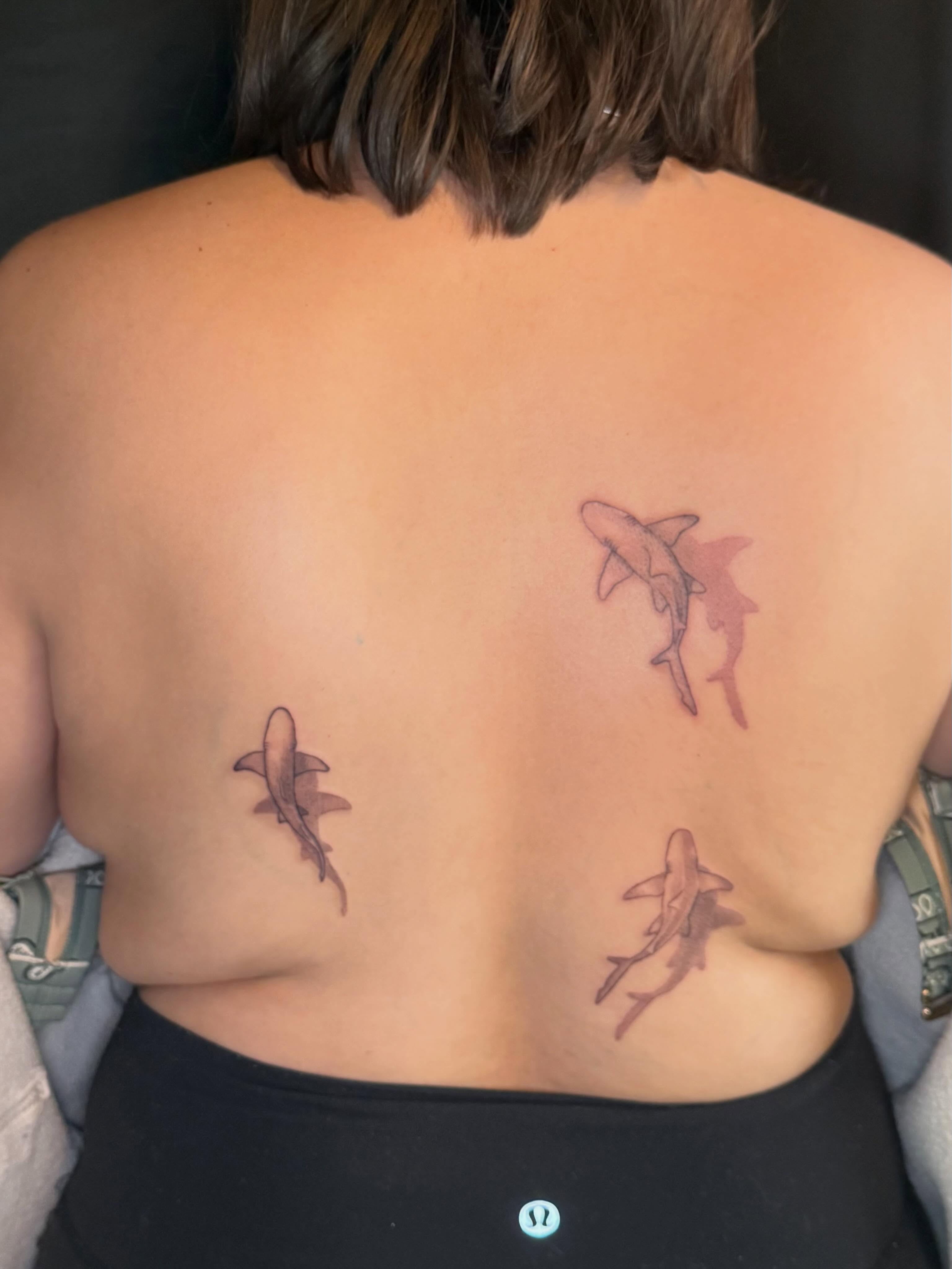 Sharks black and grey tattoo on the back by Olivia, Royal Oak, Michigan