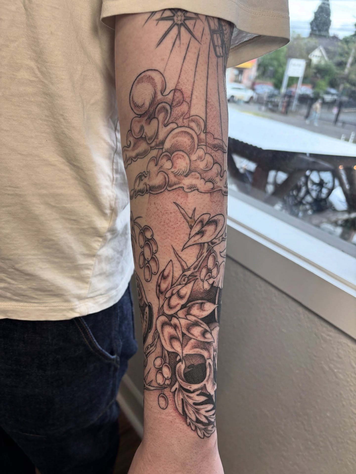 Clouds and flowers realism tattoo on the forearm by katie, Seattle, Washington