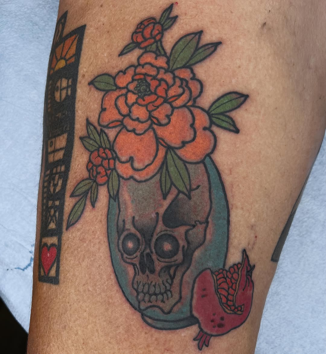 Skull with flowers and pomegranate American traditional tattoo on the forearm by Troy David Souders