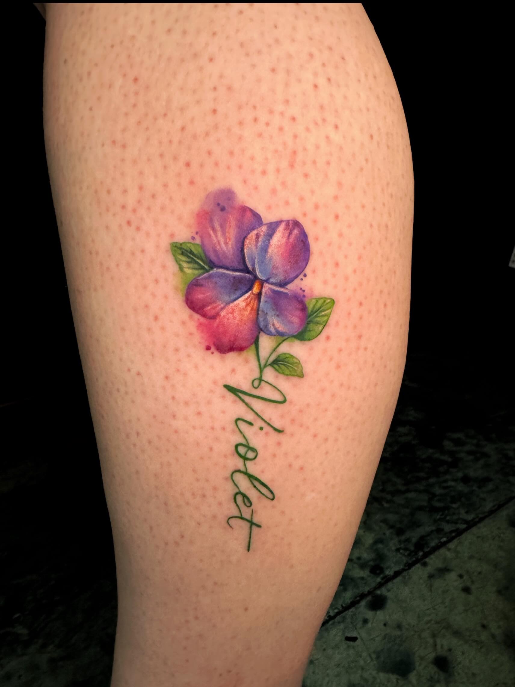 Violet flower watercolor tattoo on the thigh by Violet Michelle Williams, Charlotte, North Carolina