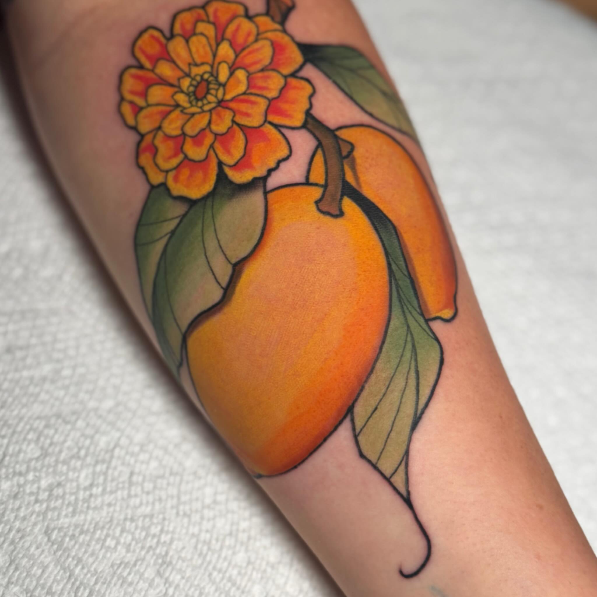Peach and flower realism tattoo on the forearm by Dylan Walker