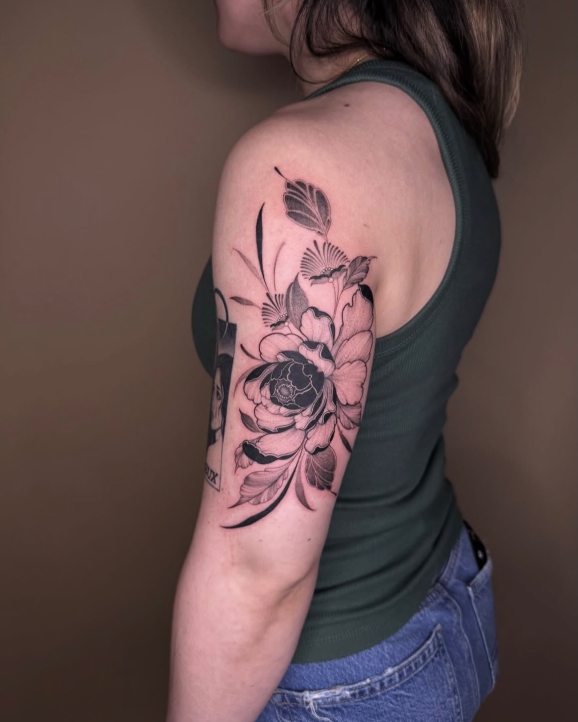 Floral arrangement black and grey tattoo on the upper arm by Jena Perry