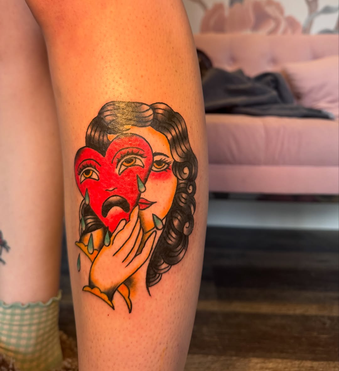 Woman holding a sad mask neo-traditional tattoo on the thigh by Kinzi Brown