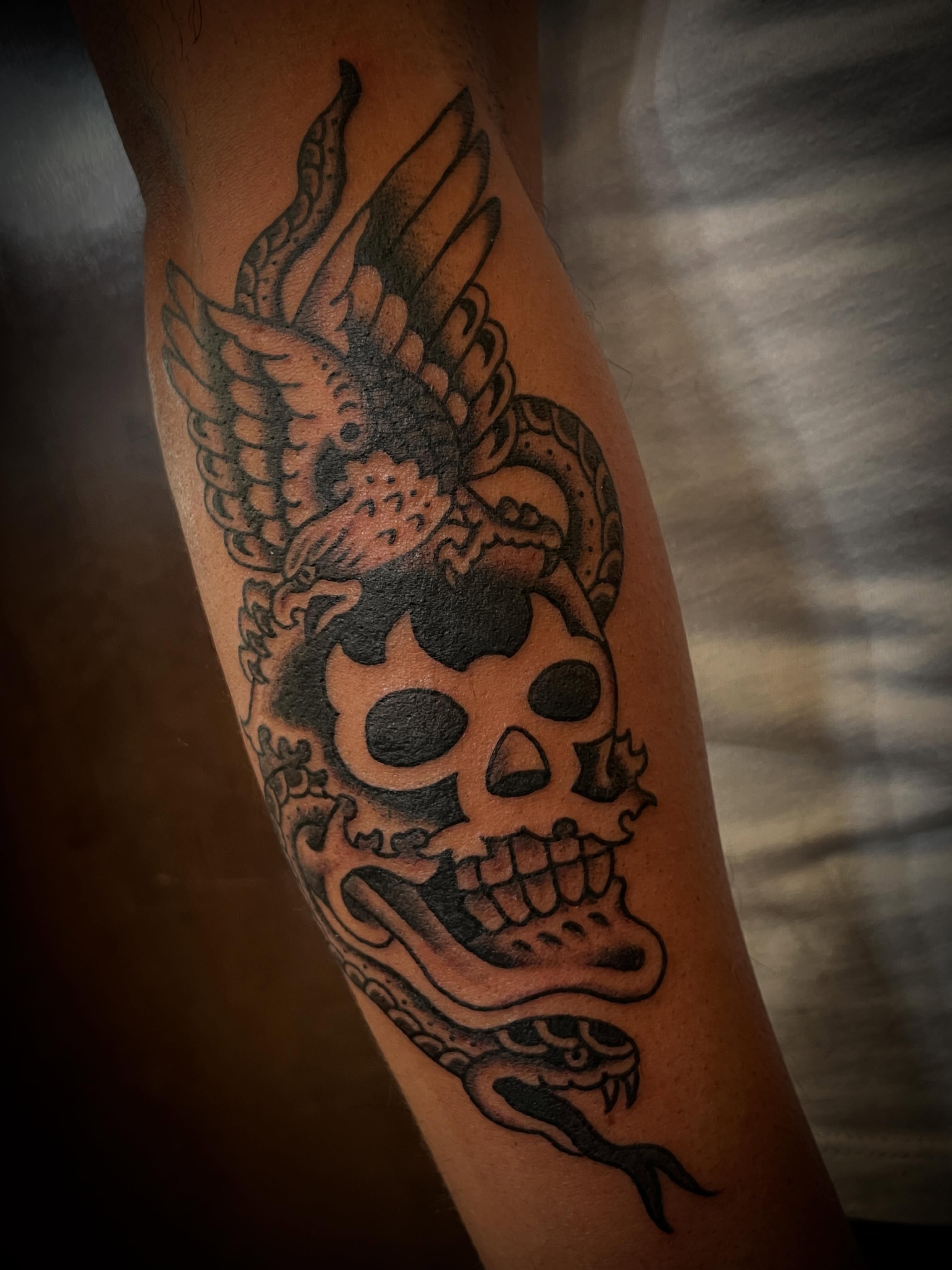 Skull with snake American traditional tattoo on the forearm by Nick Wallin
