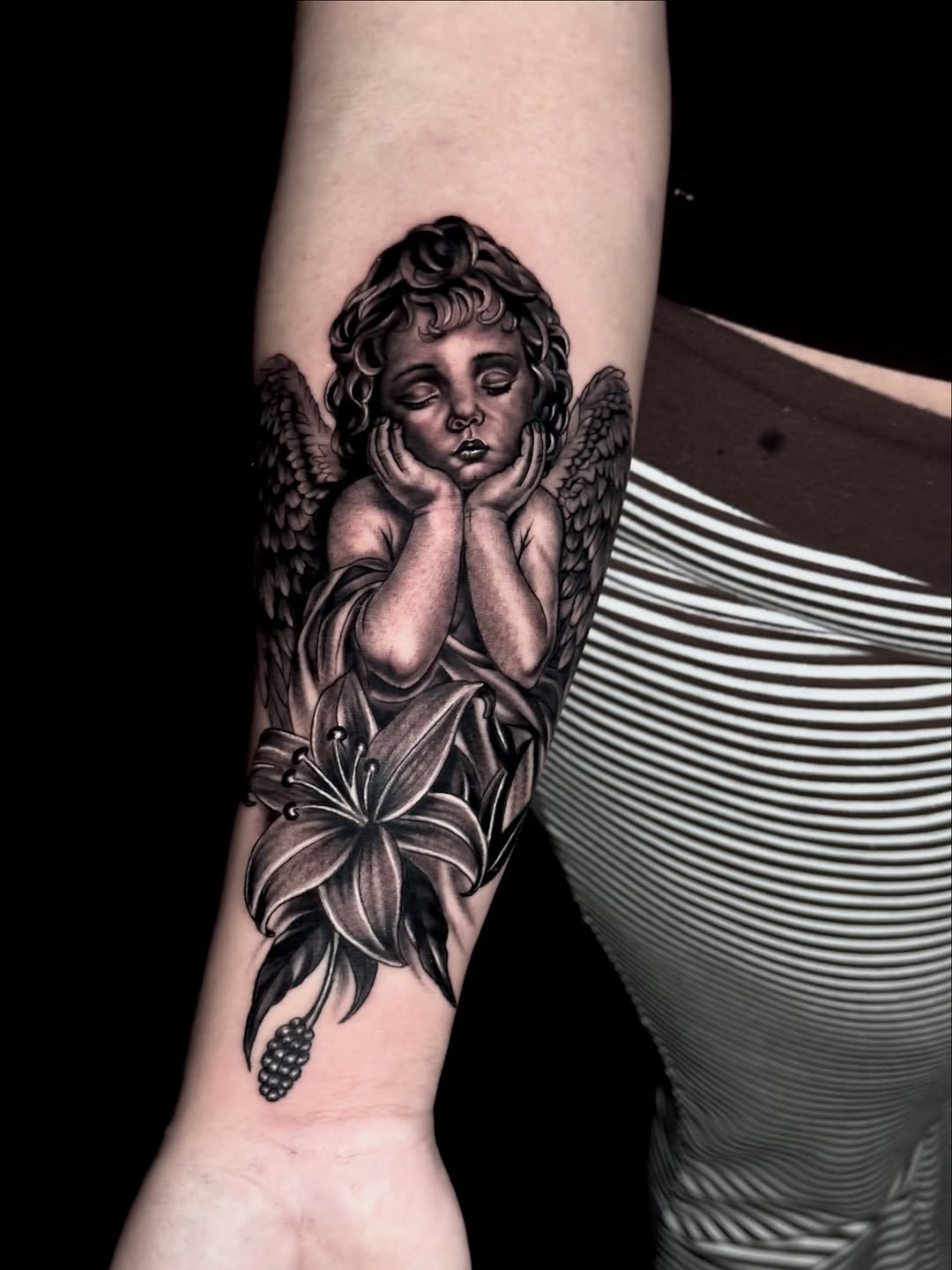 Cherub with lily realism tattoo on the forearm by Chris galvis, Charlotte, North Carolina