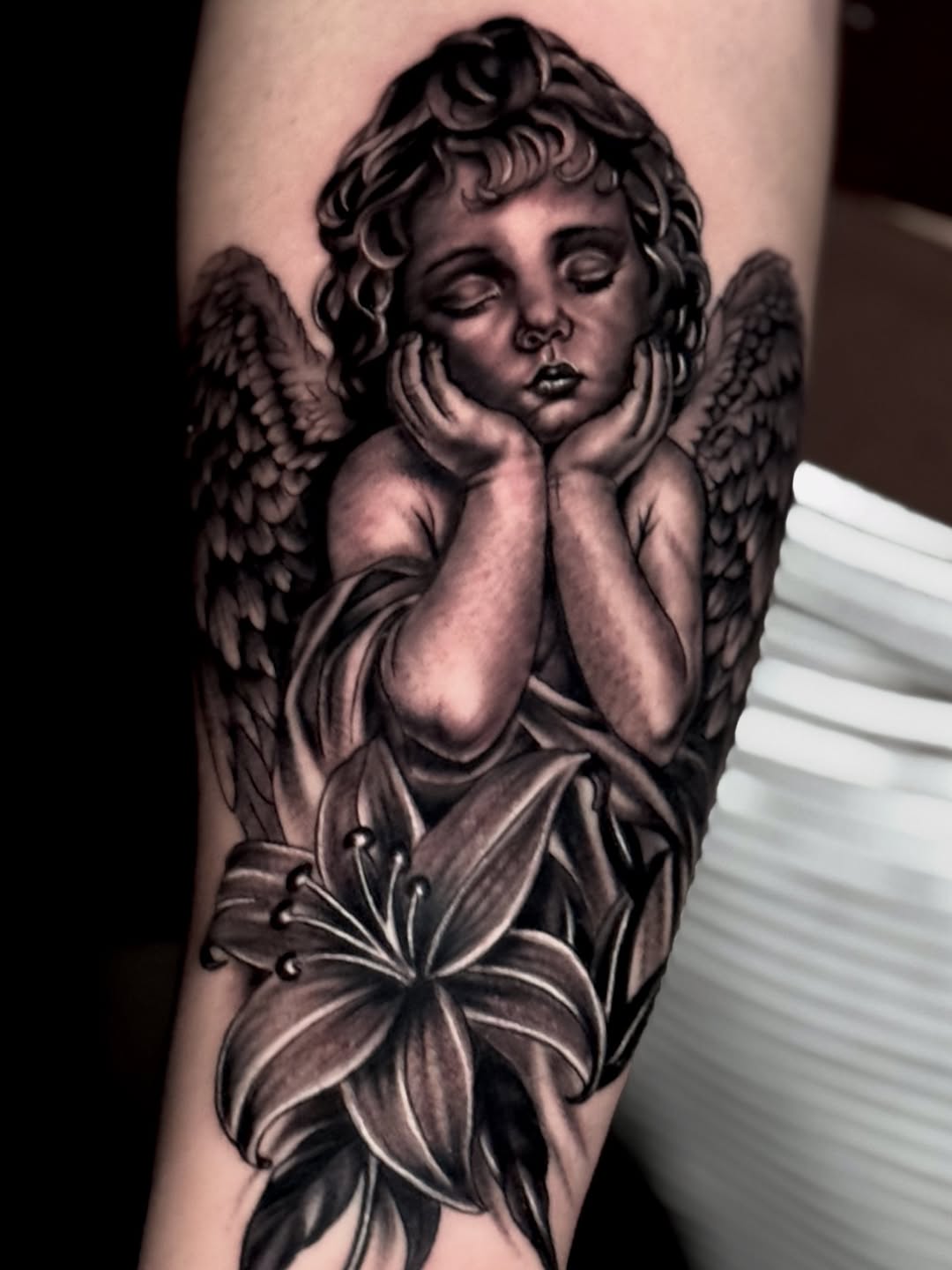 Cherub with lily realism tattoo on the forearm by Chris galvis, Charlotte, North Carolina