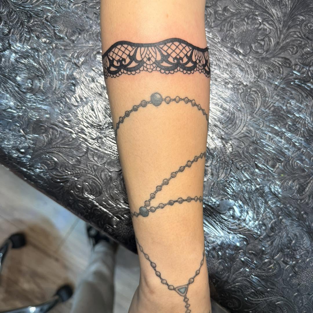 Lace and rosary black and grey tattoo on the forearm by Destiny A