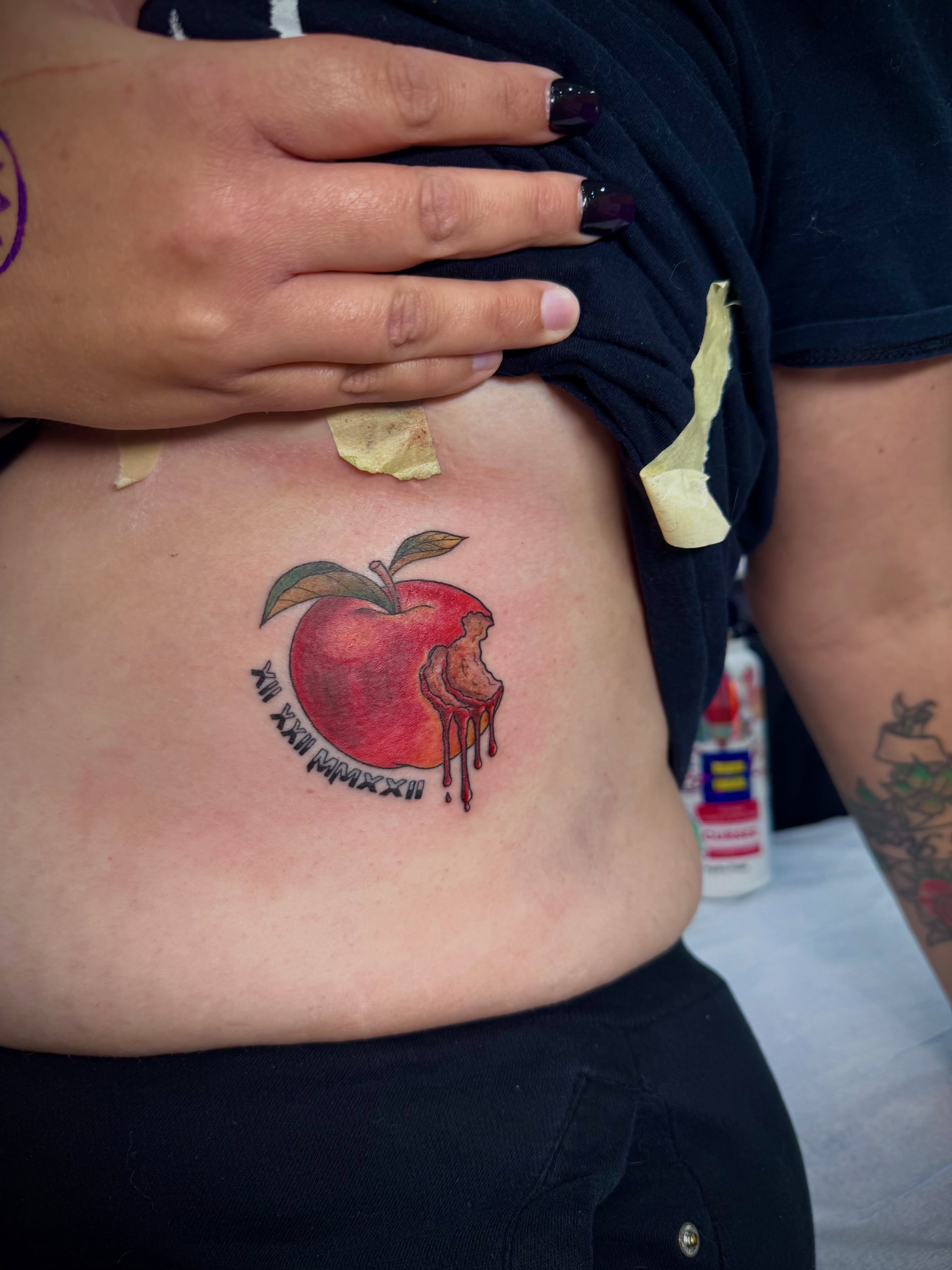 Apple realism tattoo on the ribs by Kylie Allen