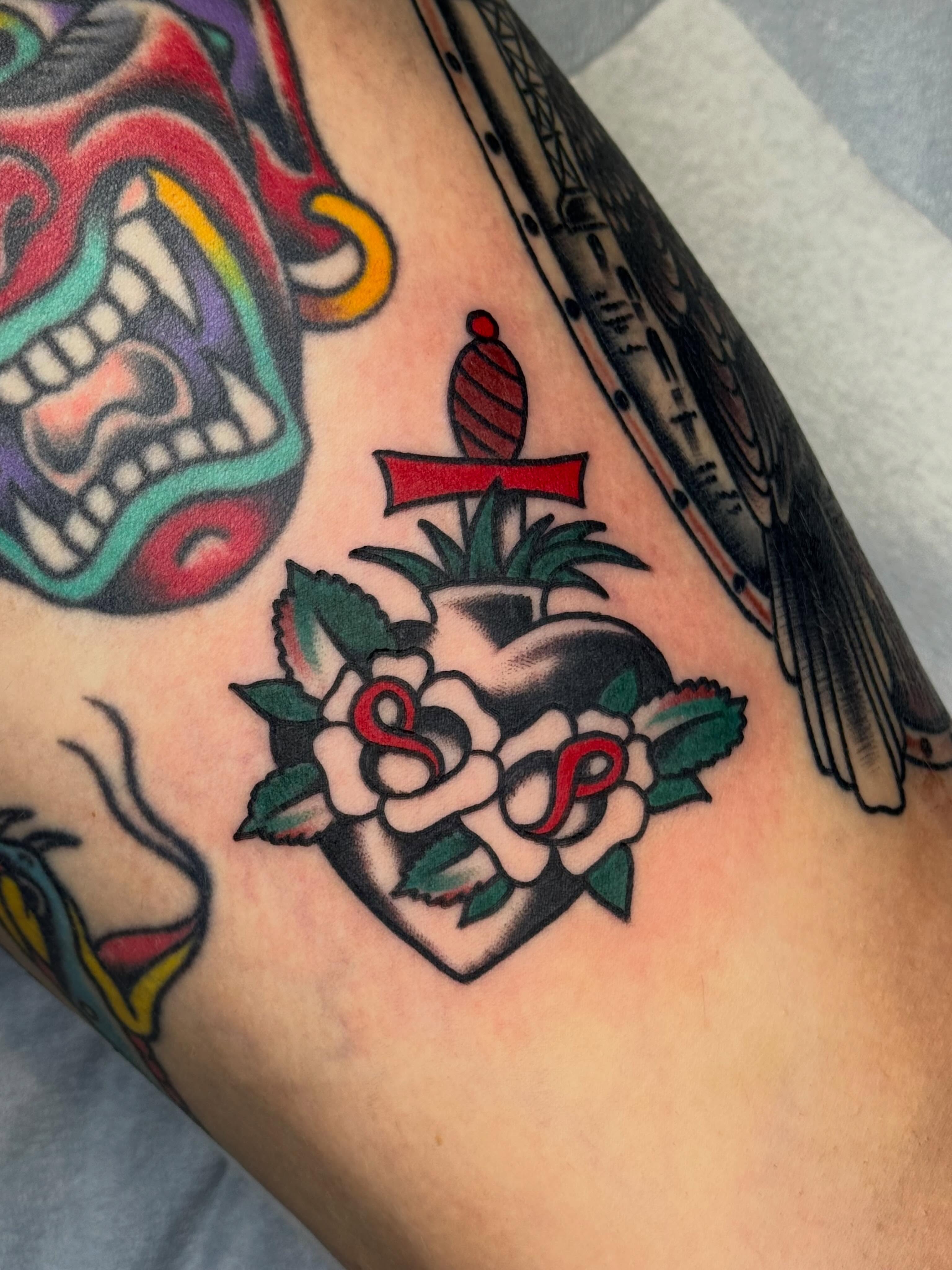 Heart with roses American traditional tattoo on the forearm by Clayton - TRADITIONAL TATTOOS