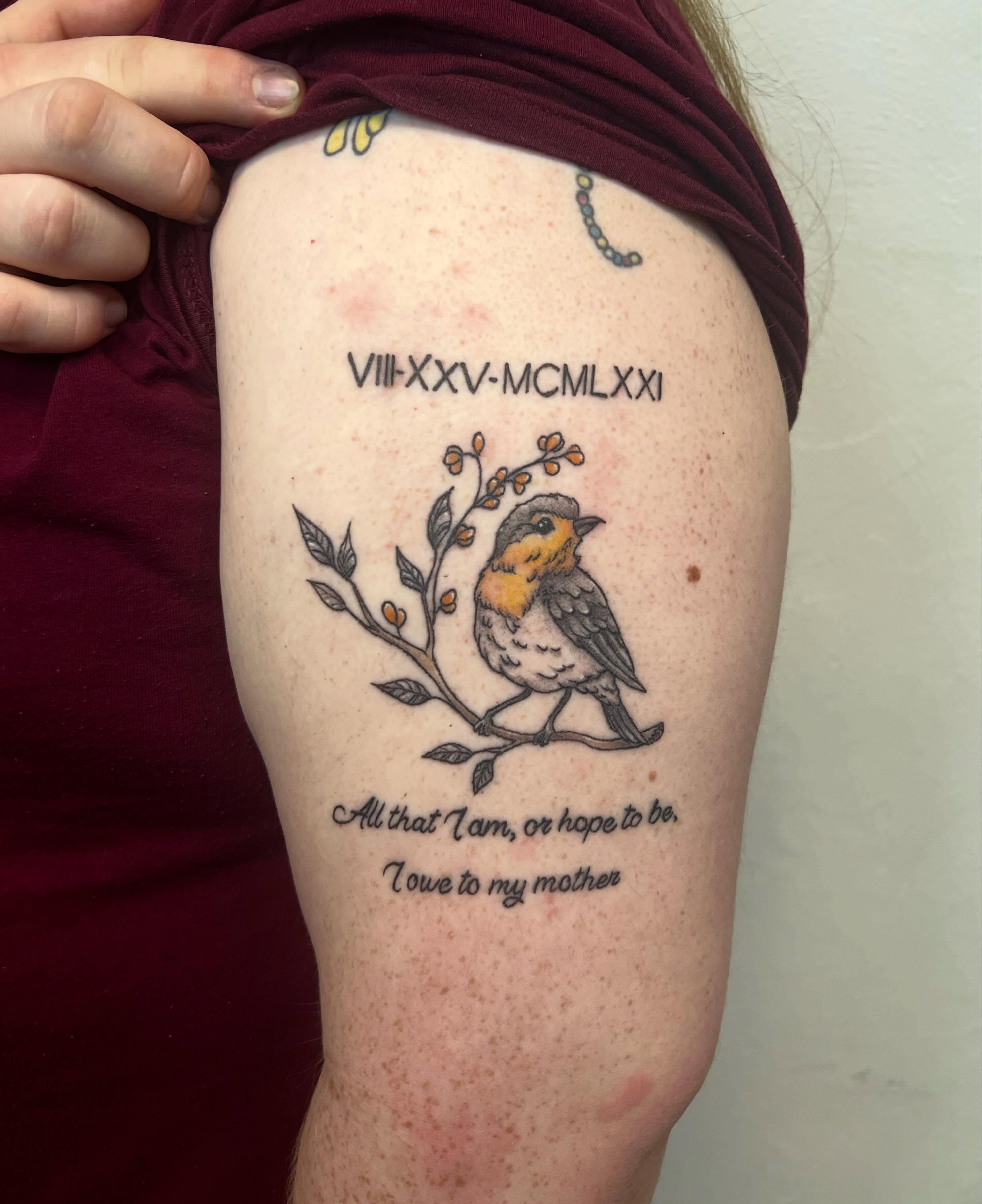 Bird and branch fine line tattoo on the upper arm by Amber Rose