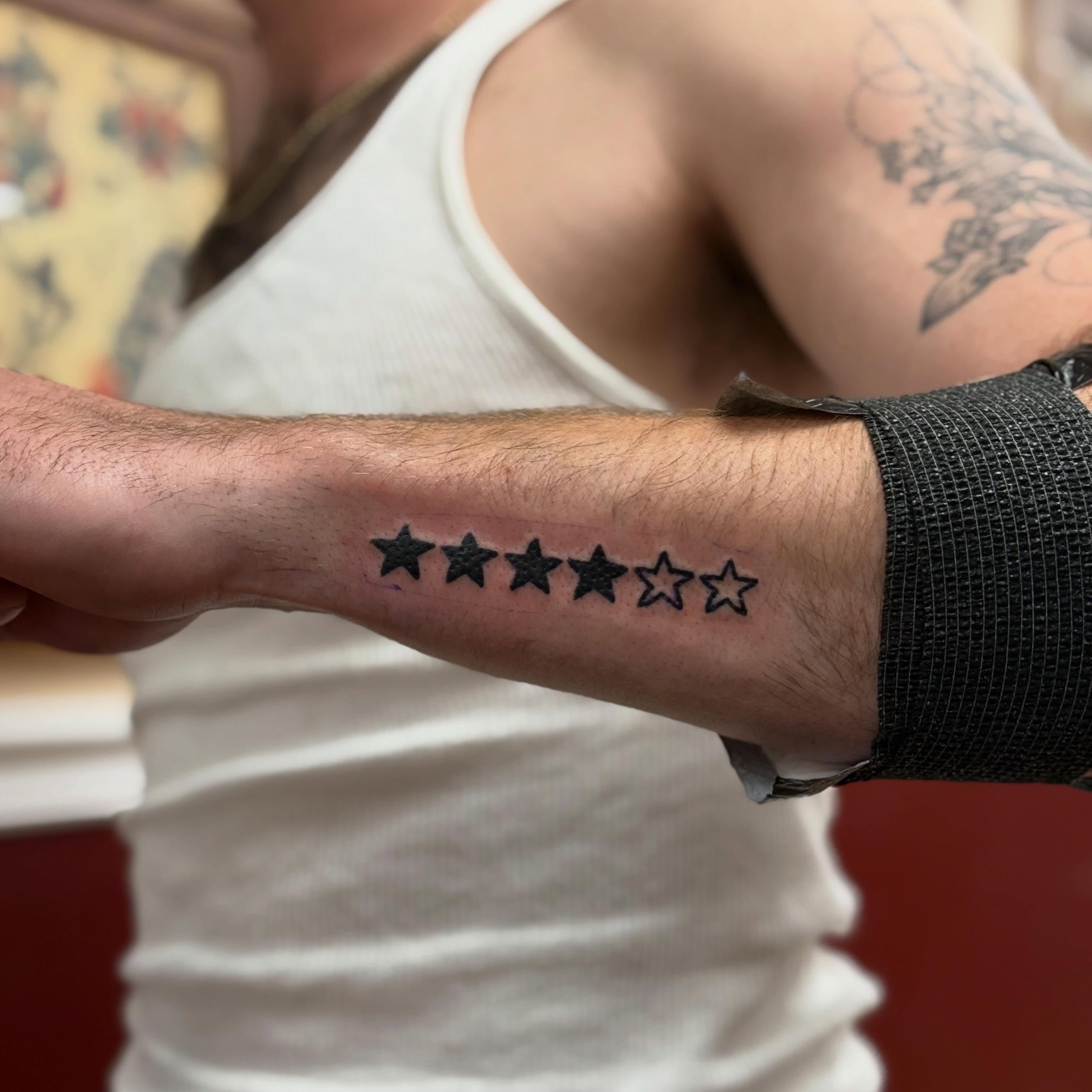 Stars black and grey tattoo on the forearm by Ben