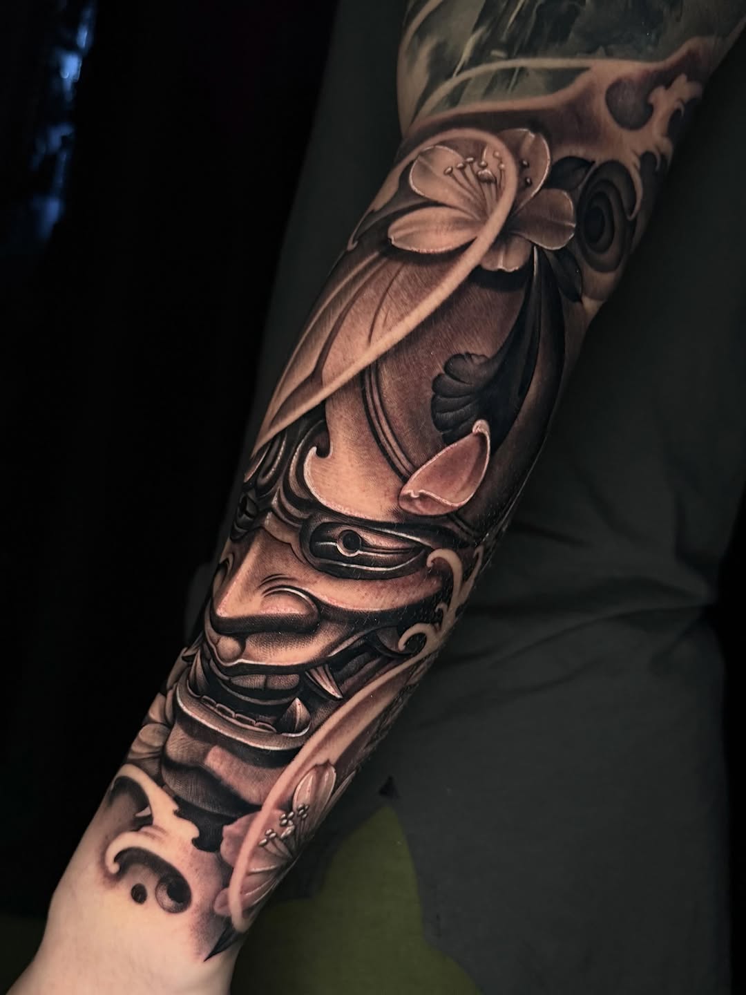 Oni mask and cherry blossoms Japanese tattoo on the forearm by Sean Flood
