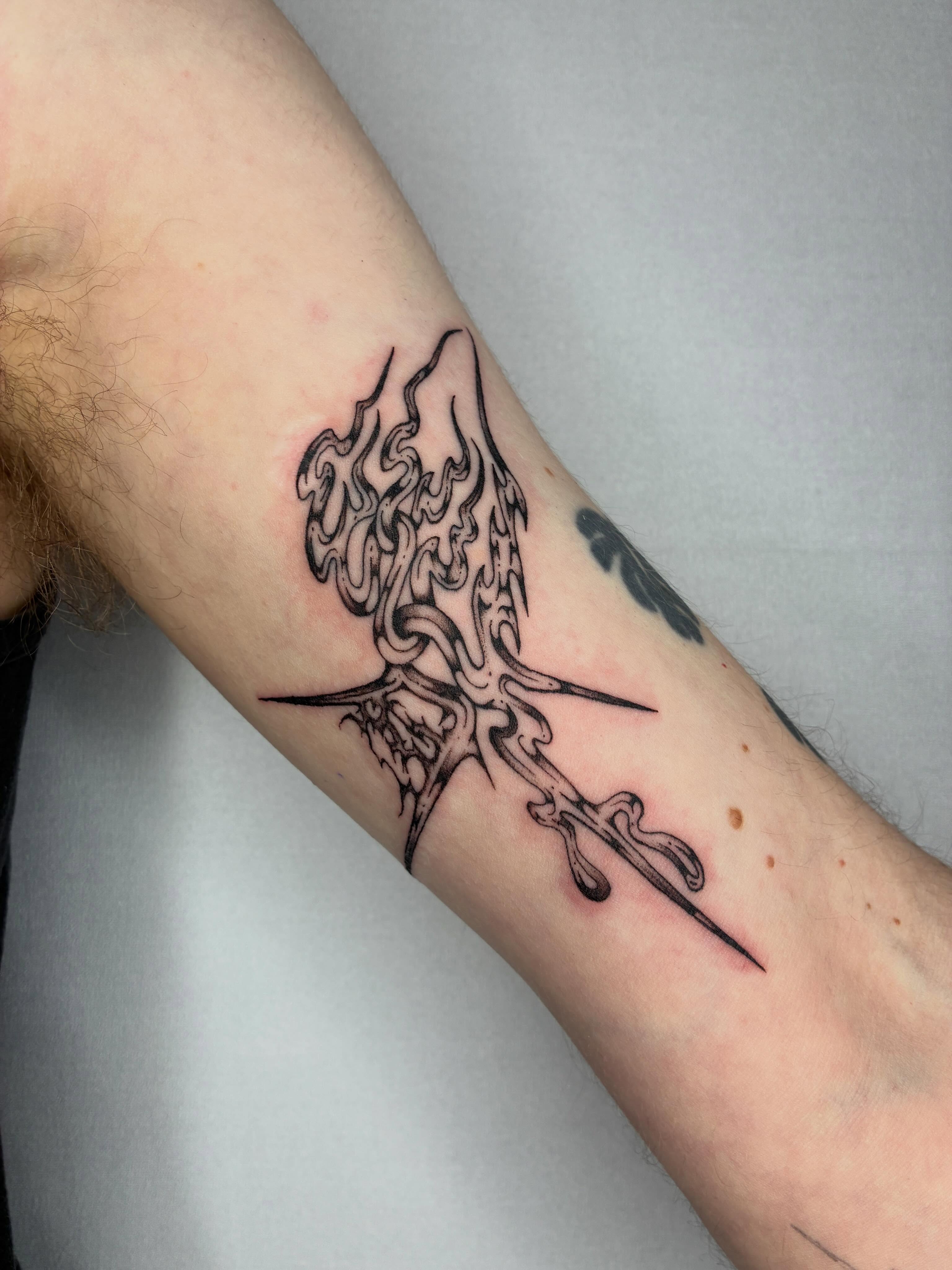 Flame and dagger black and grey tattoo on the forearm by Steven Sessler, San Francisco, California