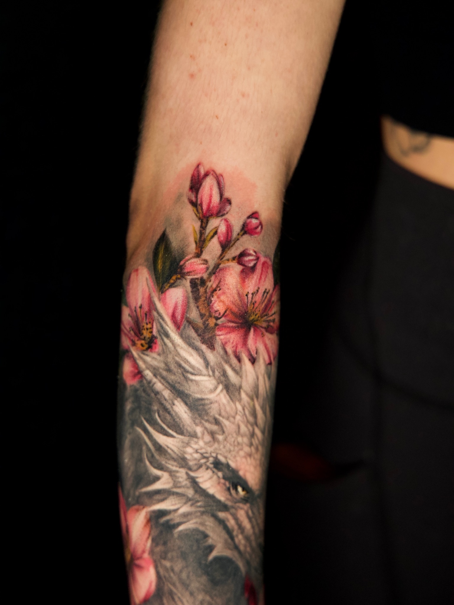 Wolf and blossoms realism tattoo on the forearm by Júlia Sorrino