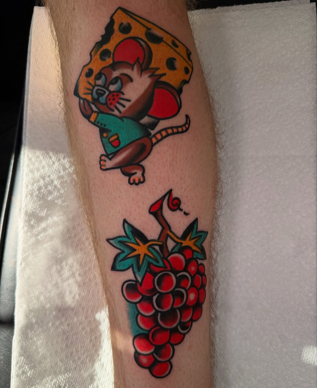 Mouse and cheese American traditional tattoo on the forearm by {{Theo Glanton}}