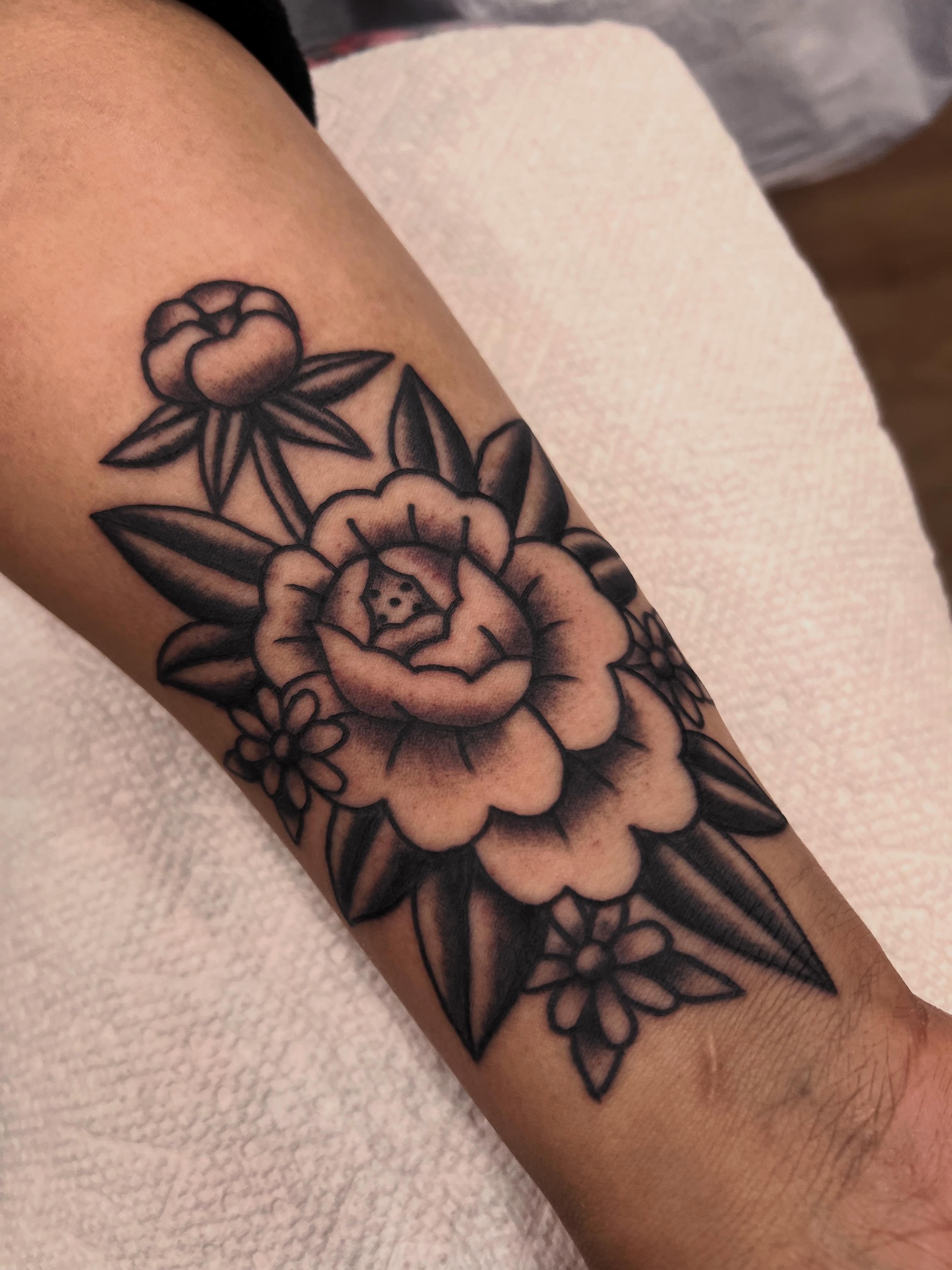 Floral arrangement black and grey tattoo on the forearm by Samantha Citer