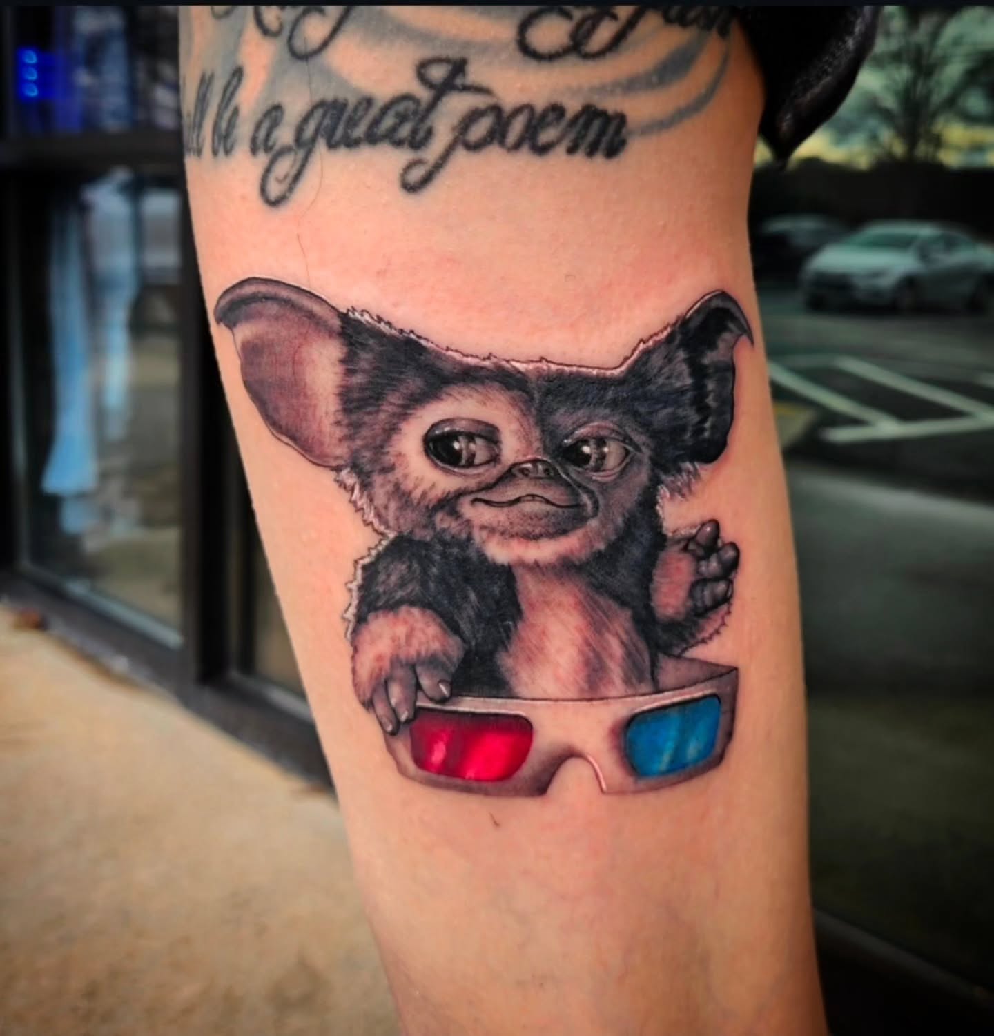 Gremlin wearing 3D glasses realism tattoo on the forearm by Mike Bugenhagen
