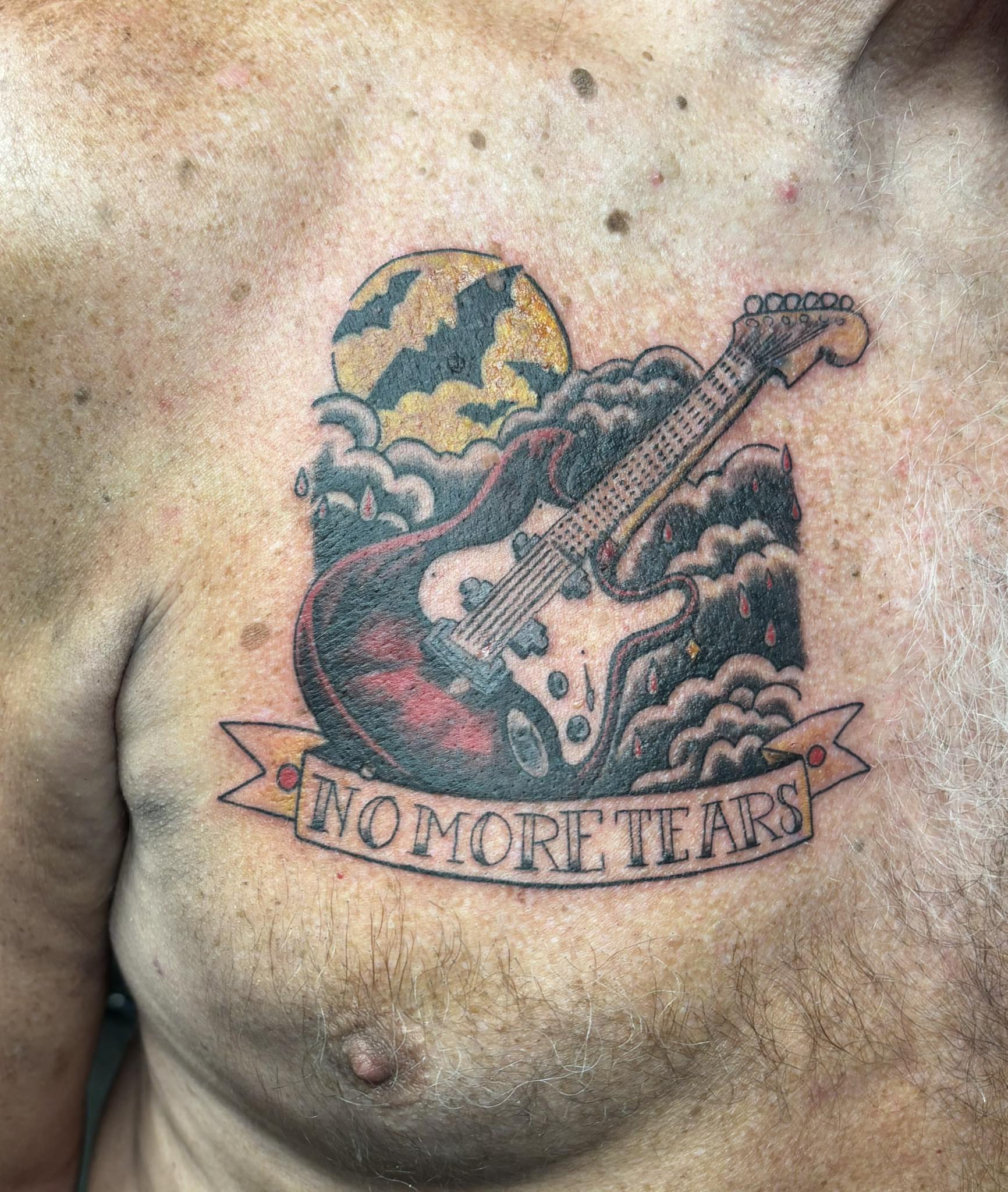 Electric guitar American traditional tattoo on the chest by Jeff Zuptich