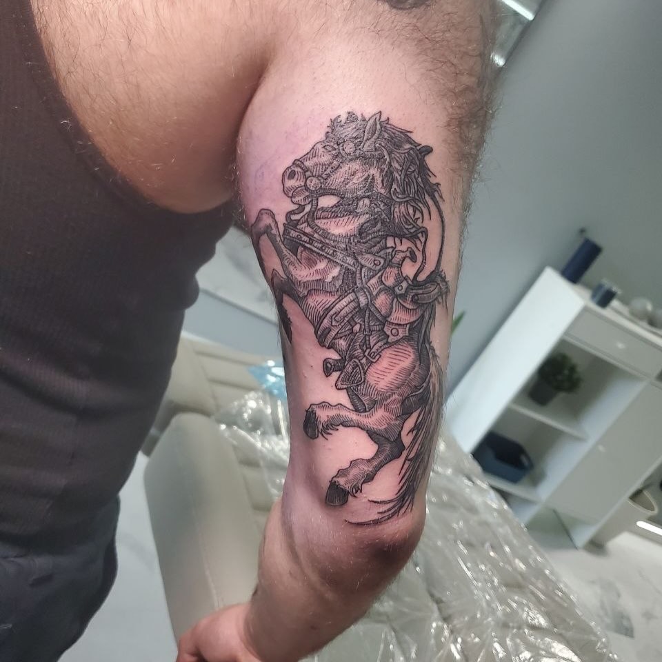 Horse and rider black and grey tattoo on the forearm by Matthew Ray, Harrisburg, North Carolina
