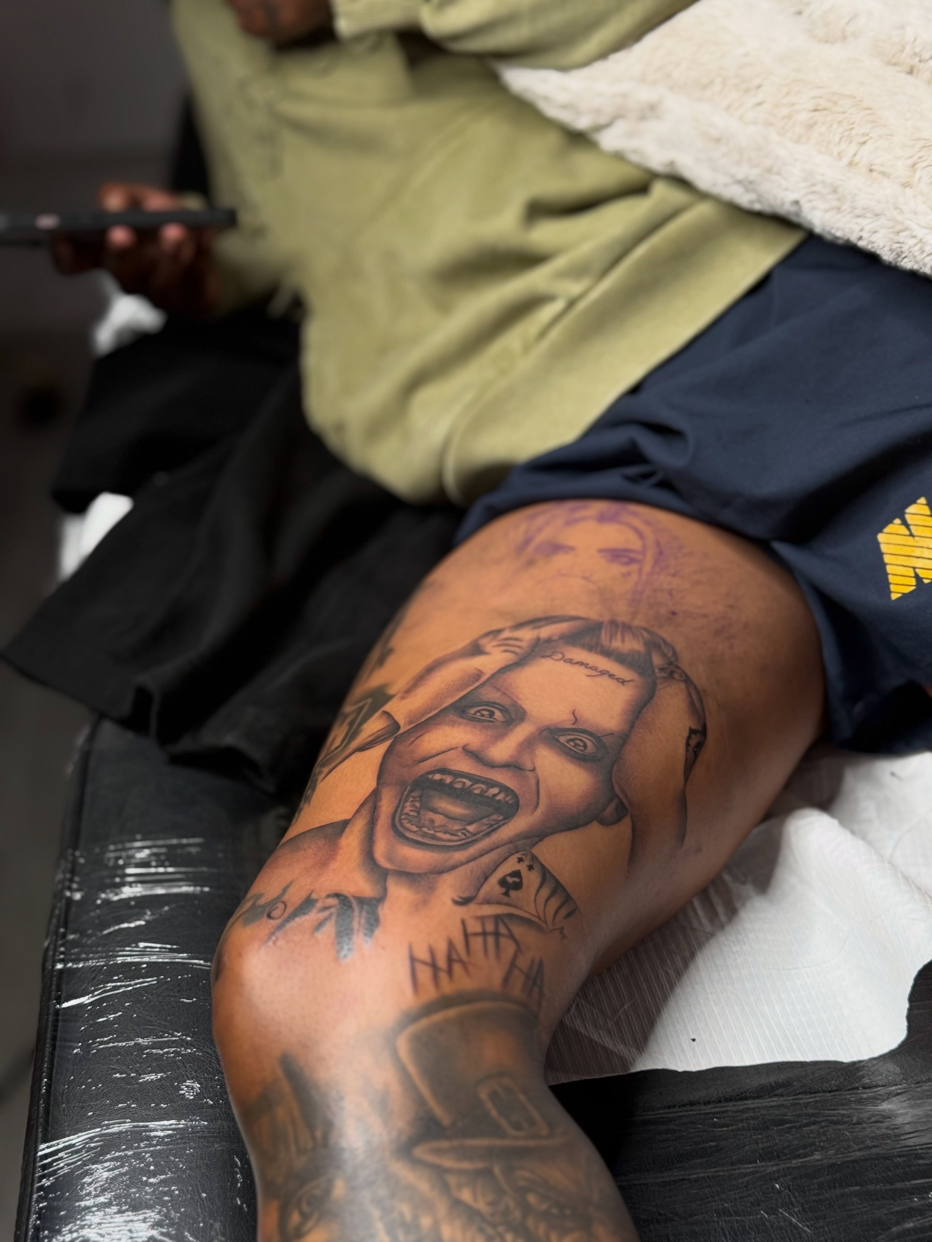 Joker black and grey tattoo on the thigh by Savannah Tattoo Artist