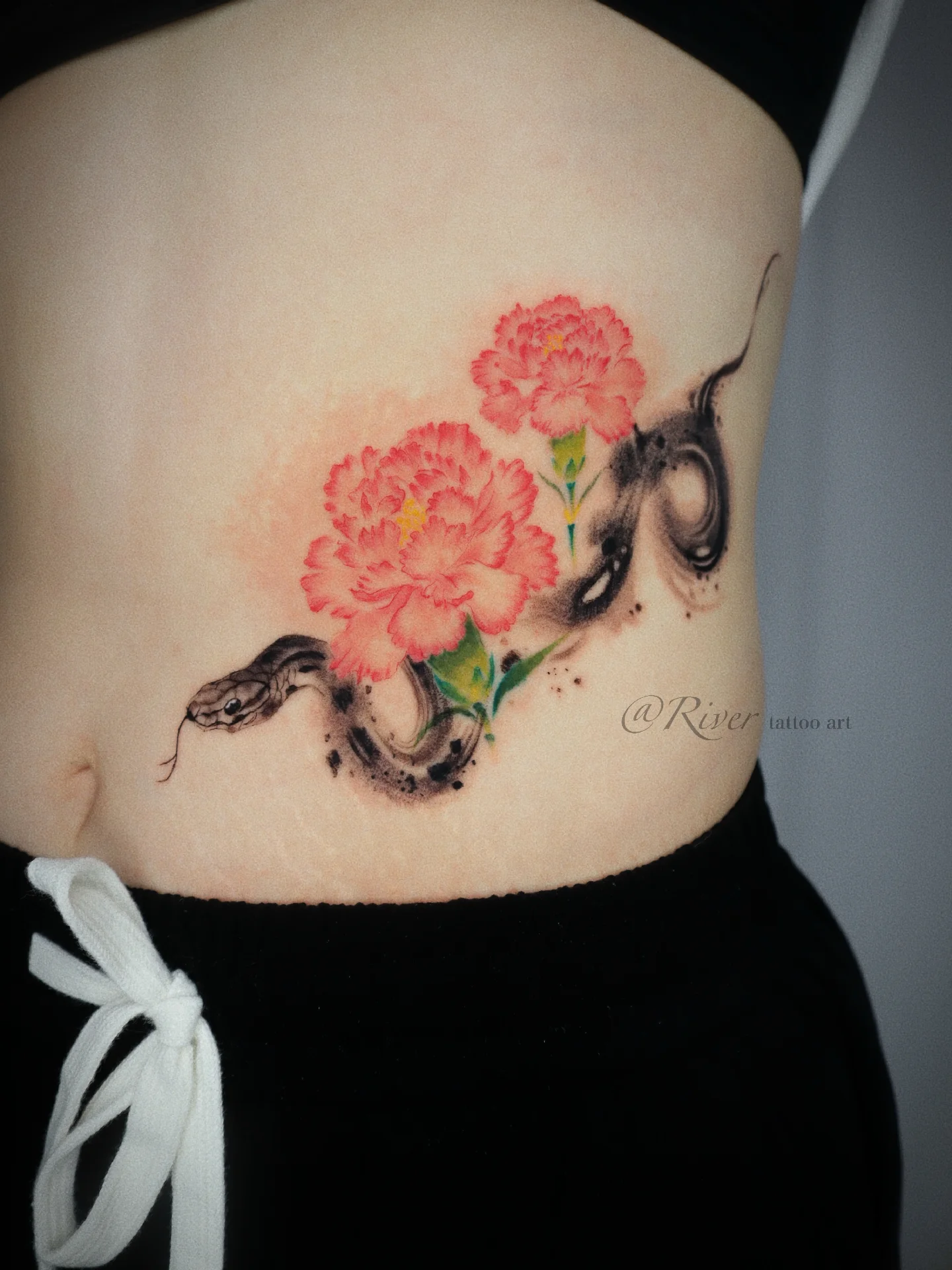 Snake and peony realism tattoo on the torso by River