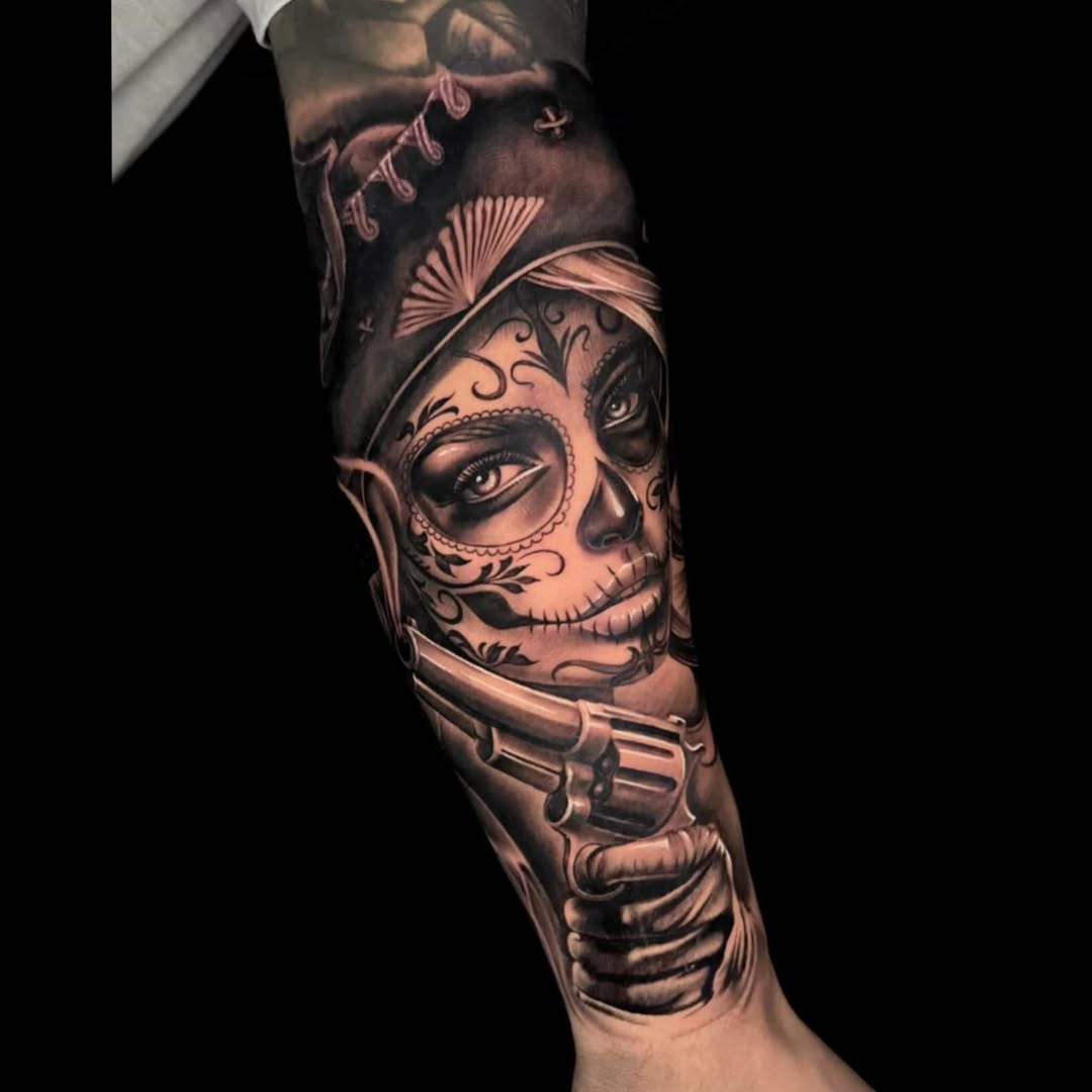 Sugar skull woman with gun Chicano tattoo on the forearm by Sean Flood
